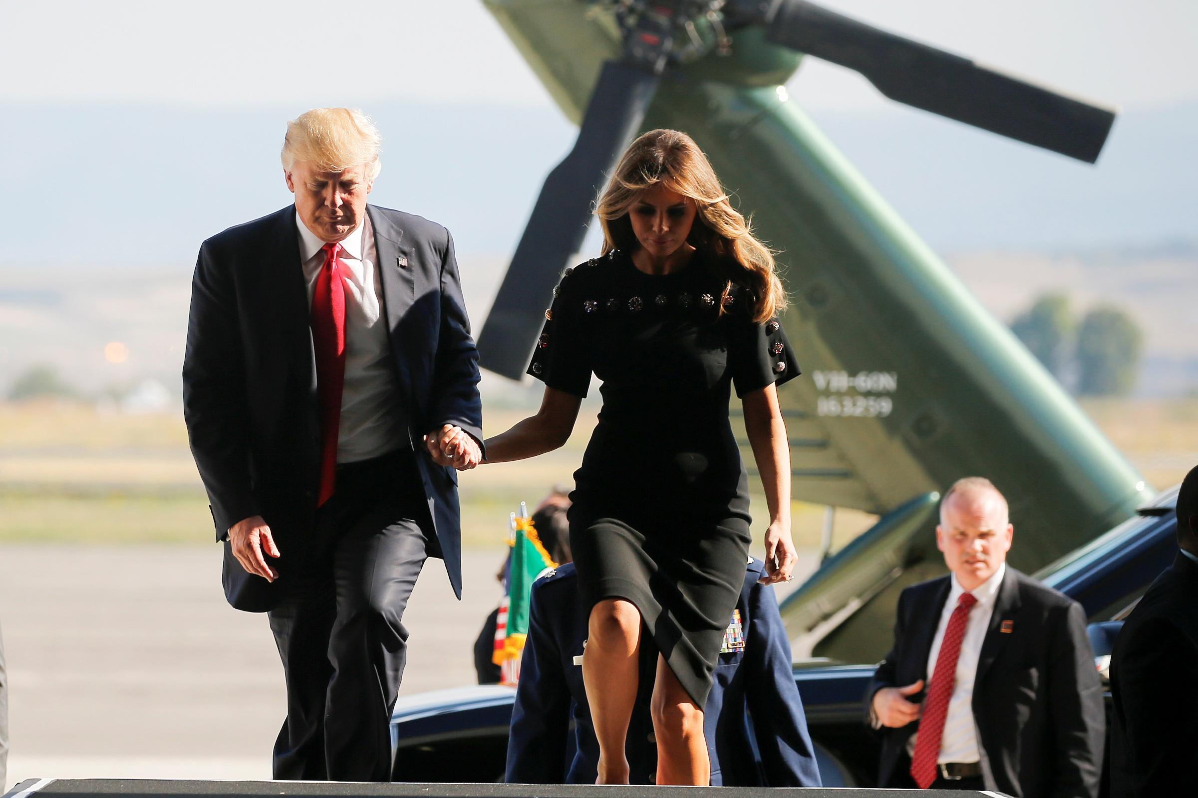 U.S. President Trump and first lady Melania Trump hold hands as they arrive at the Naval Air Station Sigonella to visit U.S. troops before returning to Washington D.C. at Sigonella Air Force Base in Sigonella