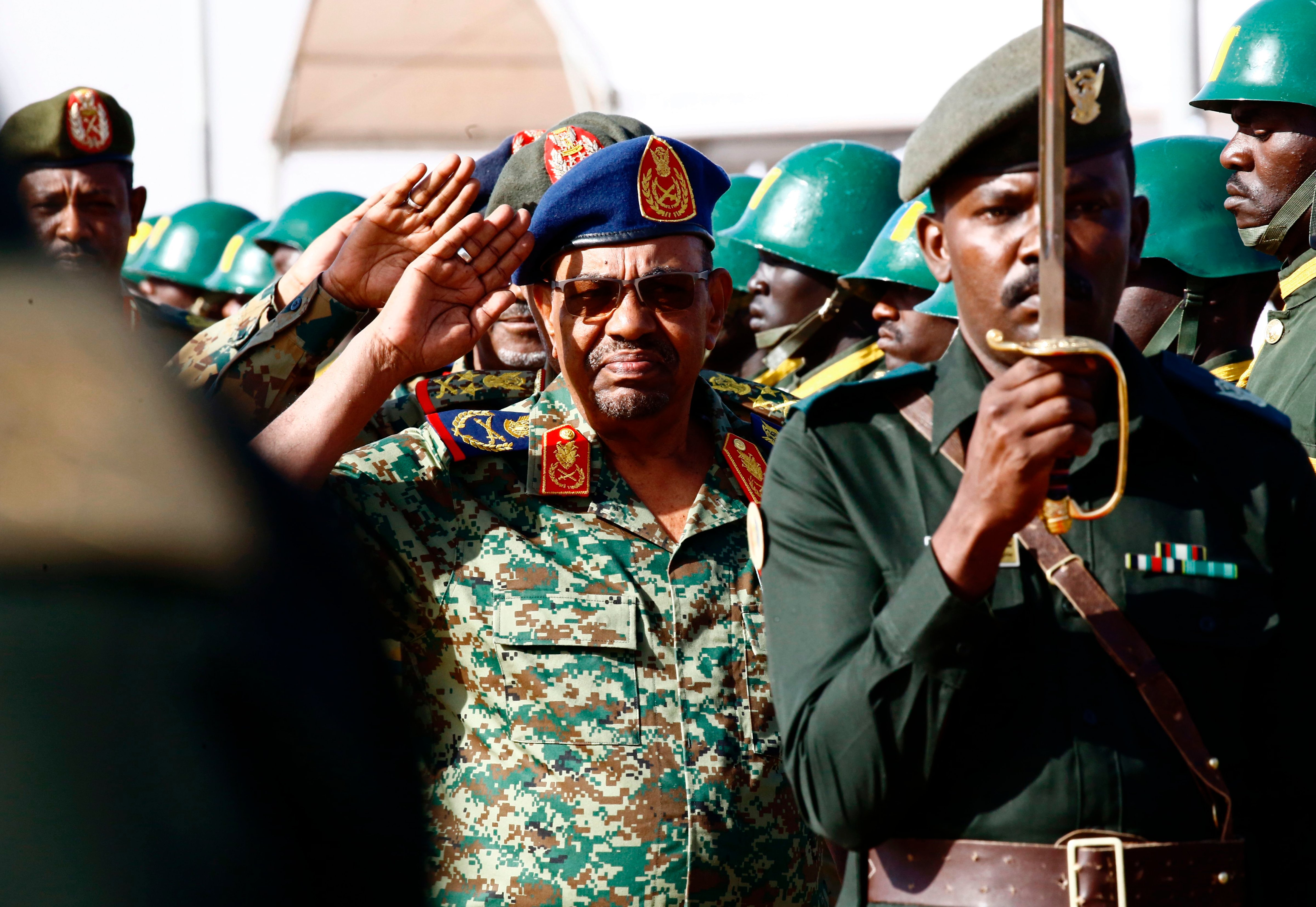 Sudanese President Omar al-Bashir (center) salutes during the joint Sudan and Saudi Arabia air force drill at the Marwa air base, on April 9, 2017. (Ashraf Shazky—AFP/Getty Images)