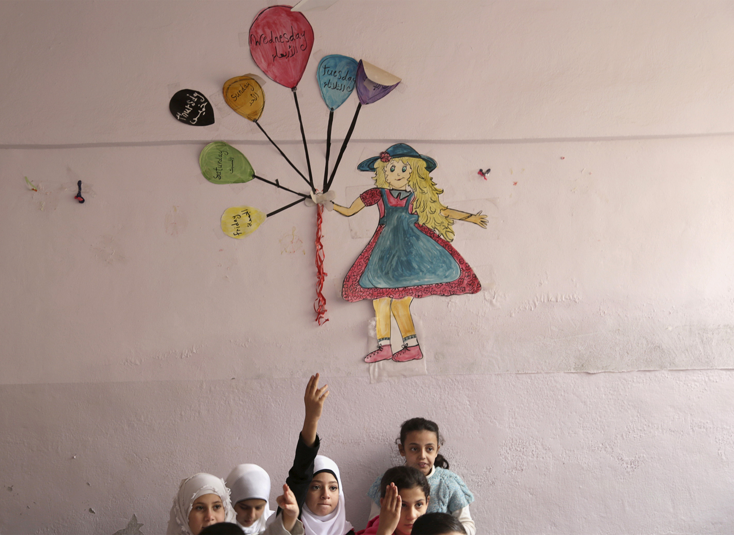 Students attend a class inside Hosam Kamel school in the rebel-controlled area of Maaret al-Numan town in Idlib province, Syria on October 28, 2015. The school, which was bombed and partially destroyed, started the new school year after restoration work was completed, activists said. (Khalil Ashawi—Reuters)