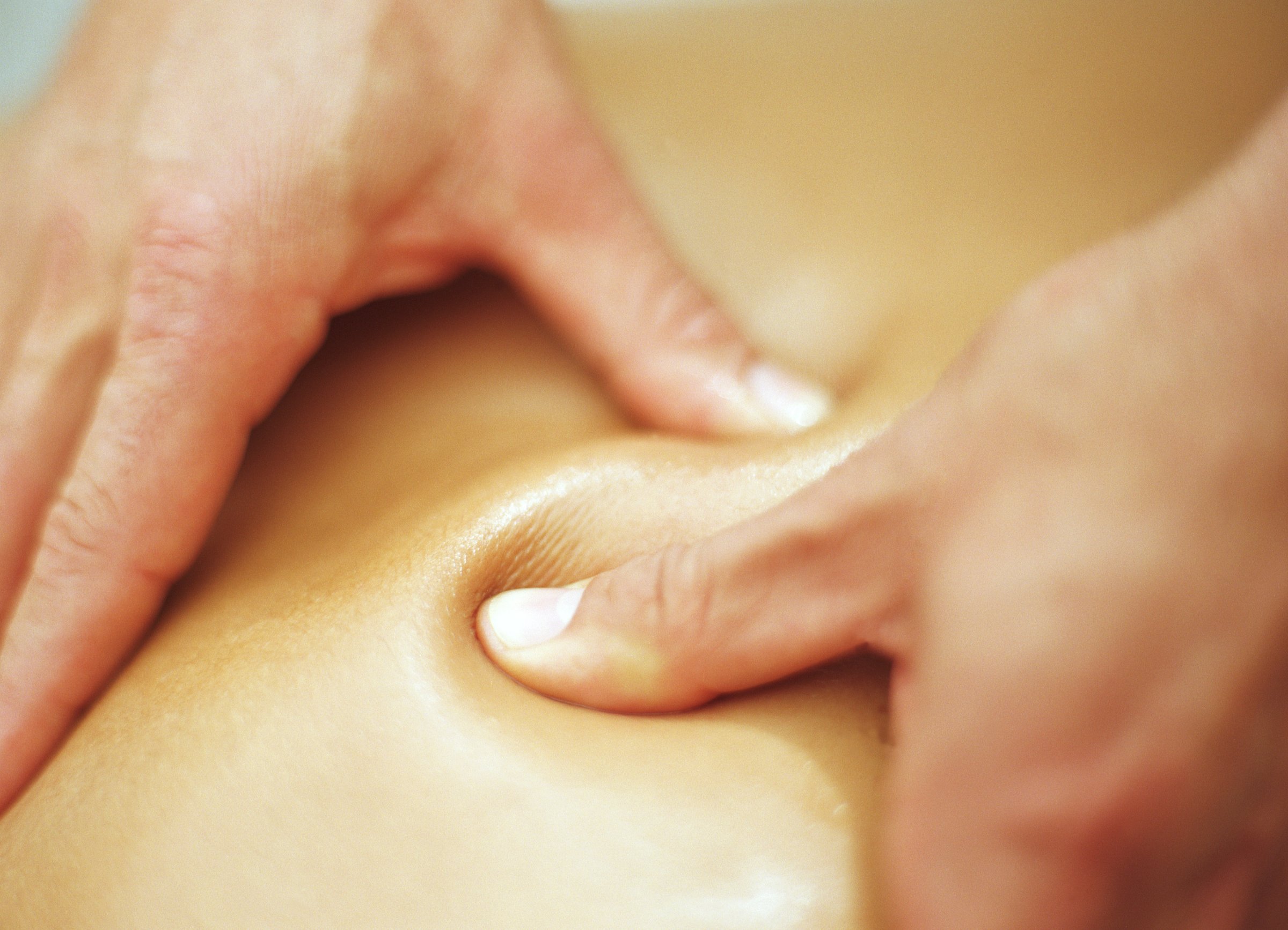 Man massaging woman, pressing thumbs into skin, close-up