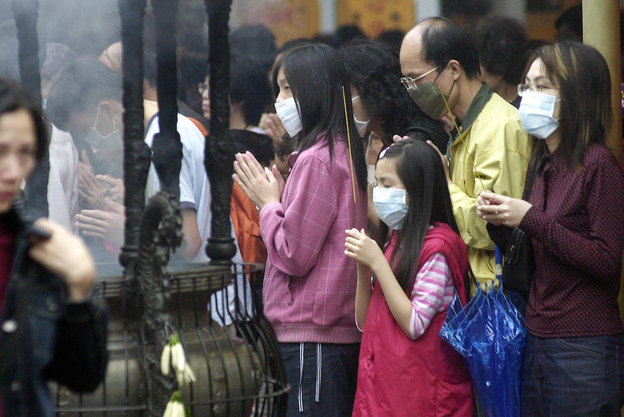 A group of Taiwanese wear face masks to protect themselves against infection from Severe Acute Respiratory Syndrome (SARS) while praying at Hsing Tien Kung Taoist temple in Taipei, in this file photo from May 18 2003. (PATRICK LIN—AFP/Getty Images)