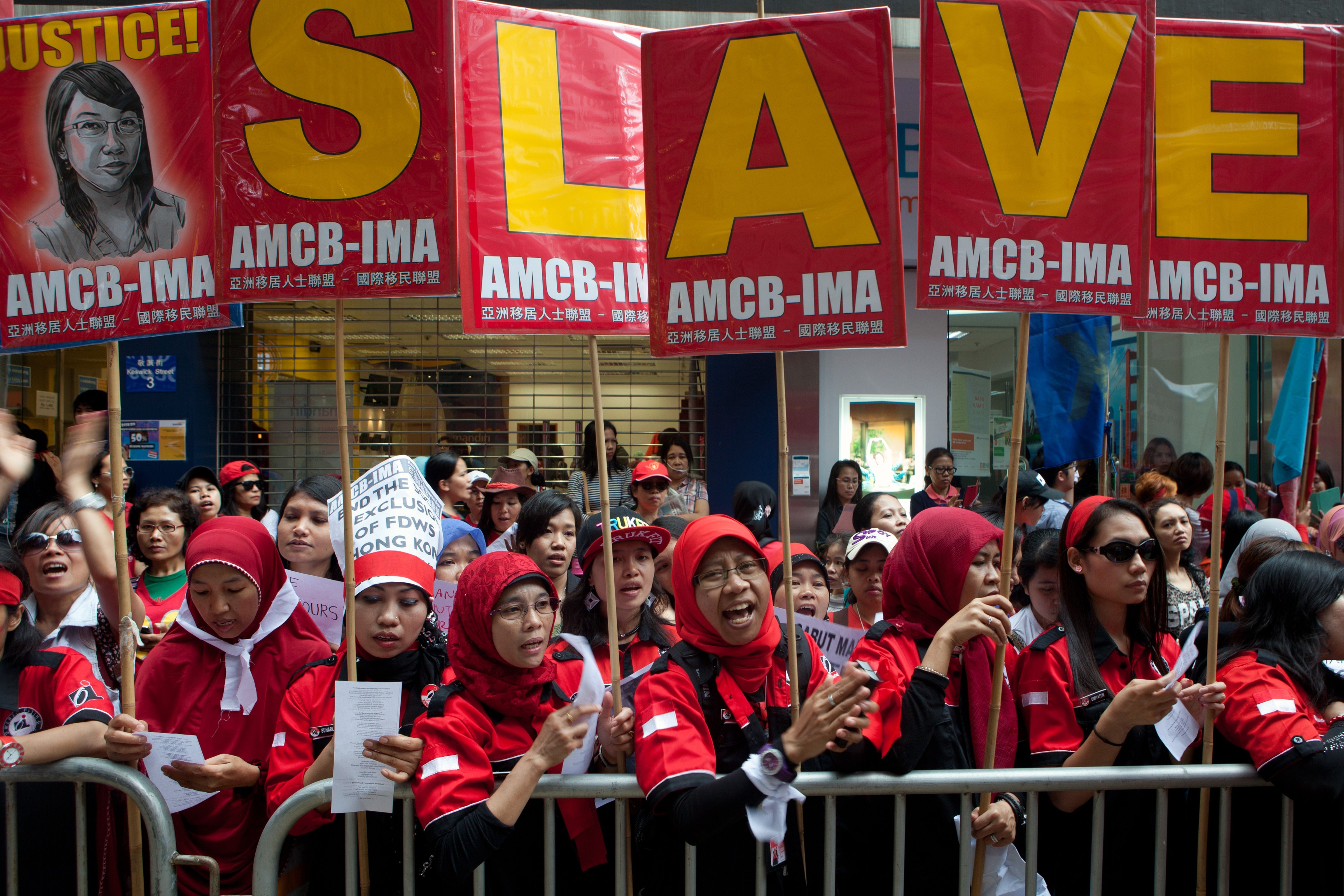 Migrant workers from Indonesia carry placards which collectively read "Slave" during a Labour Day rally in Hong Kong on May 1, 2014. (Anthony Wallace—AFP/Getty Images)