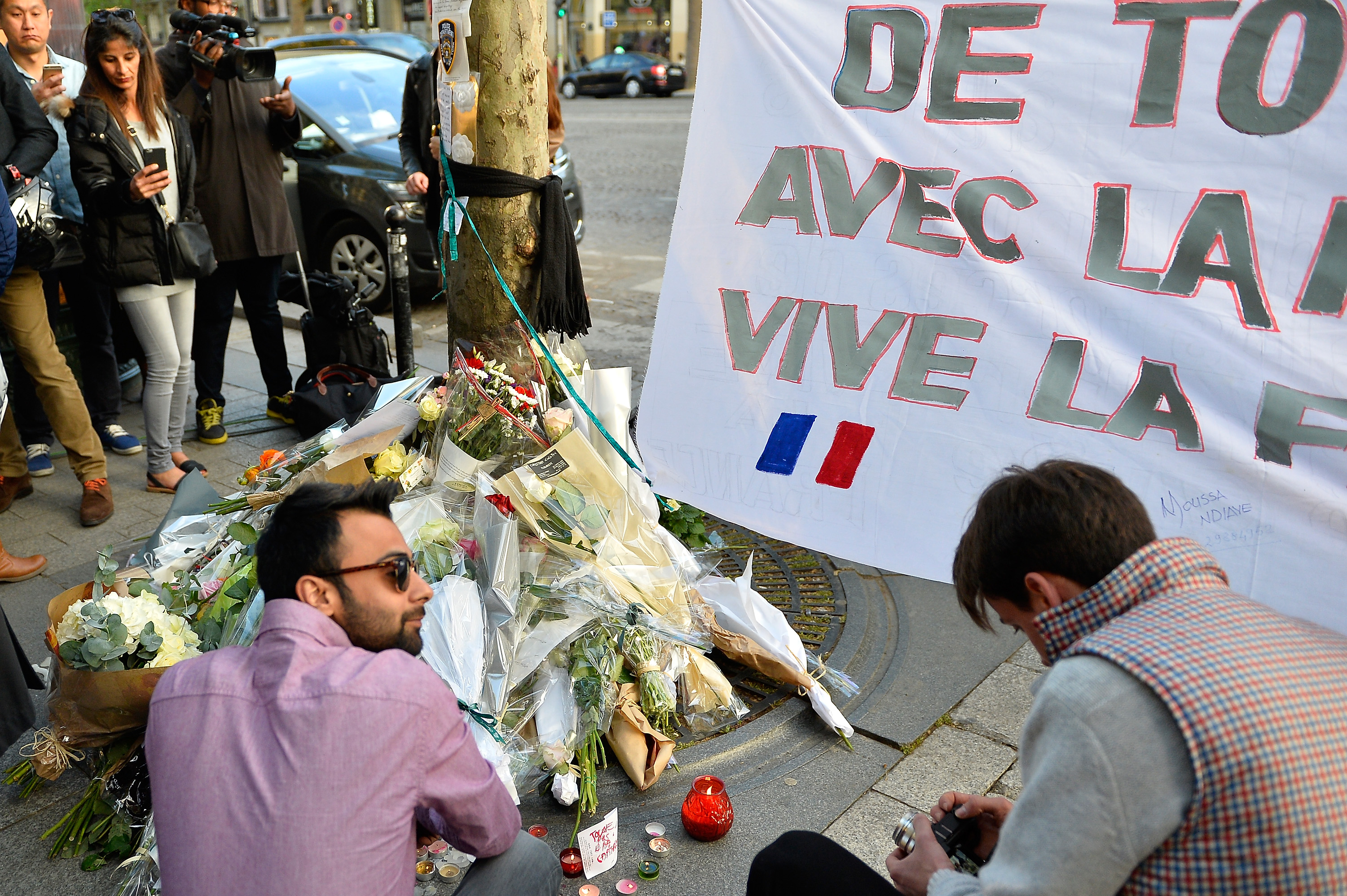 People leave flowers as a tribute to the police officer who lost his life on the Champs-Elysées boulevard in Paris when a gunman opened fire on police officers, one day after the attack, on April 21, 2017. (Aurelien Meunier—Getty Images)