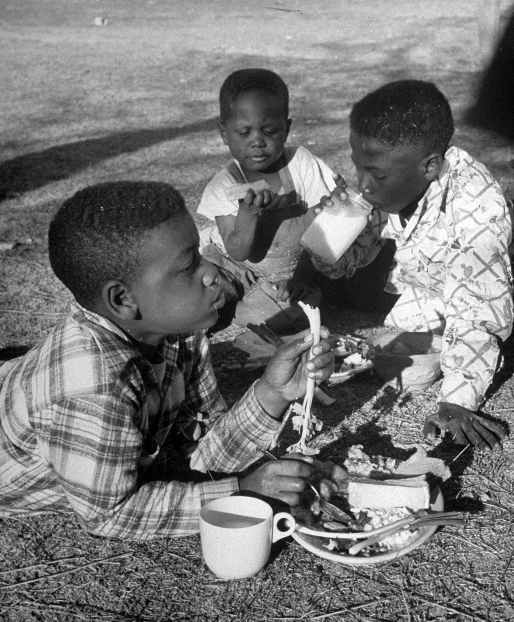 Three young boys eating a Red Cross meal in Arizona, 1950.