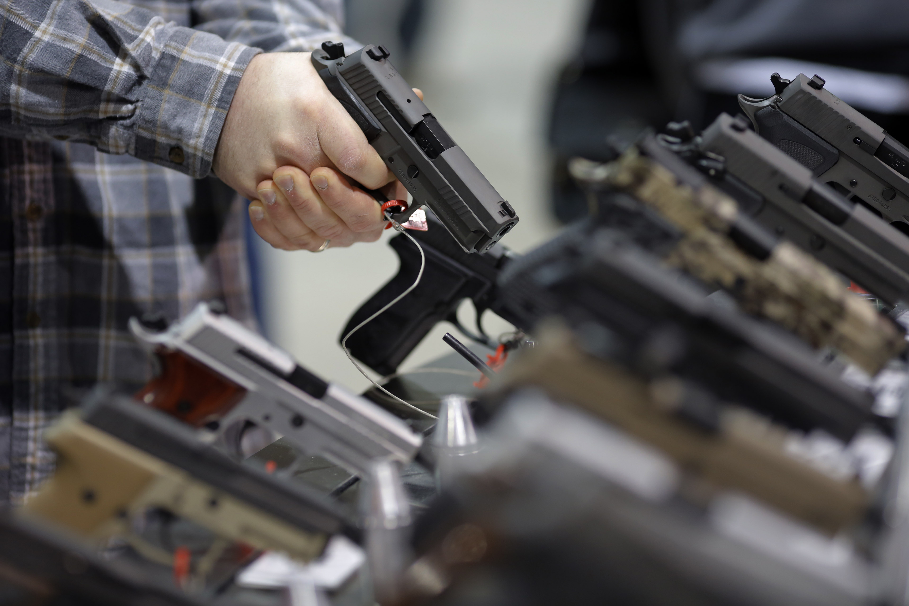 A visitor holds a pistol at a gun display during a National Rifle Association outdoor sports trade show on February 10, 2017 in Harrisburg, Pennsylvania. (Dominick Reuter—AFP/Getty Images)