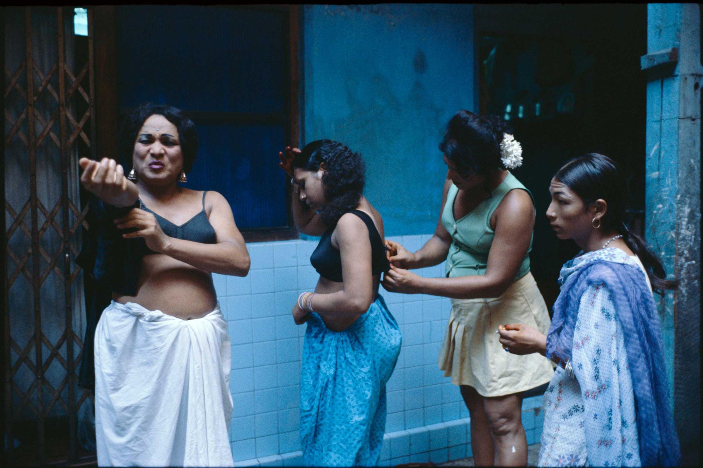 Transvestites getting dressed in a courtyard.