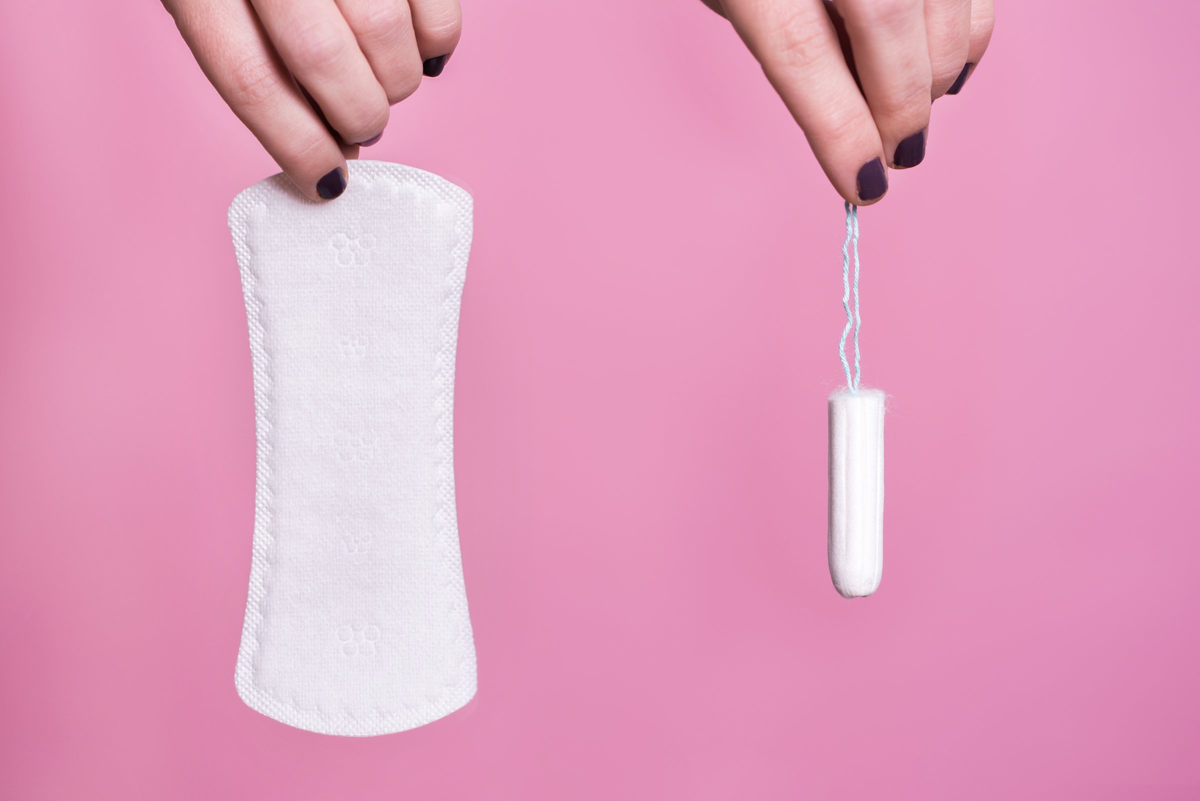 Women holding a sanitary napkin and tampon