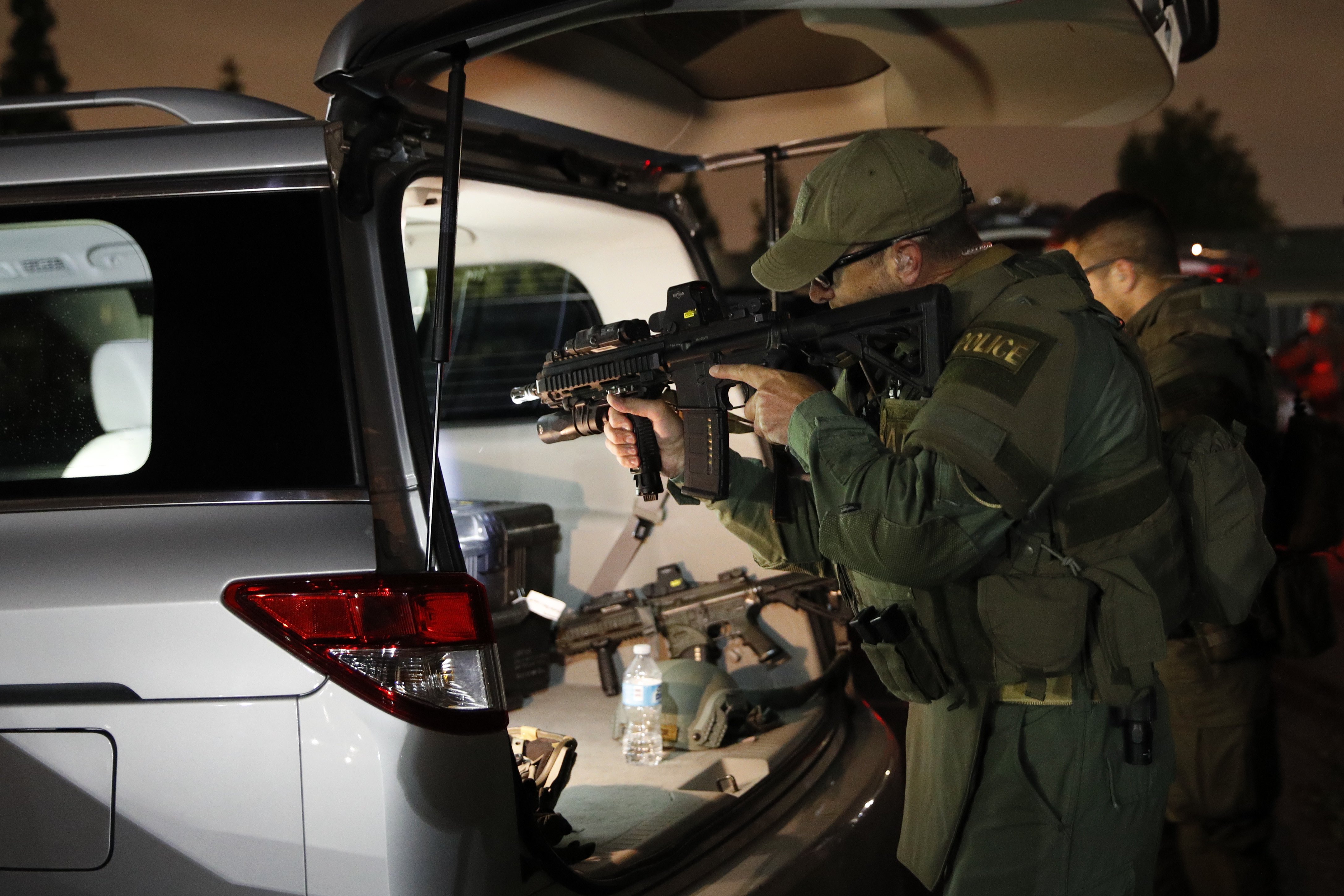An ATF agent checks his weapon as he gets ready for a raid on May 17, 2017, in Los Angeles. Hundreds of federal and local law enforcement fanned out across Los Angeles, serving arrest and search warrants as part of a three-year investigation into the violent and brutal street gang MS-13. (Jae C. Hong&mdash;AP)