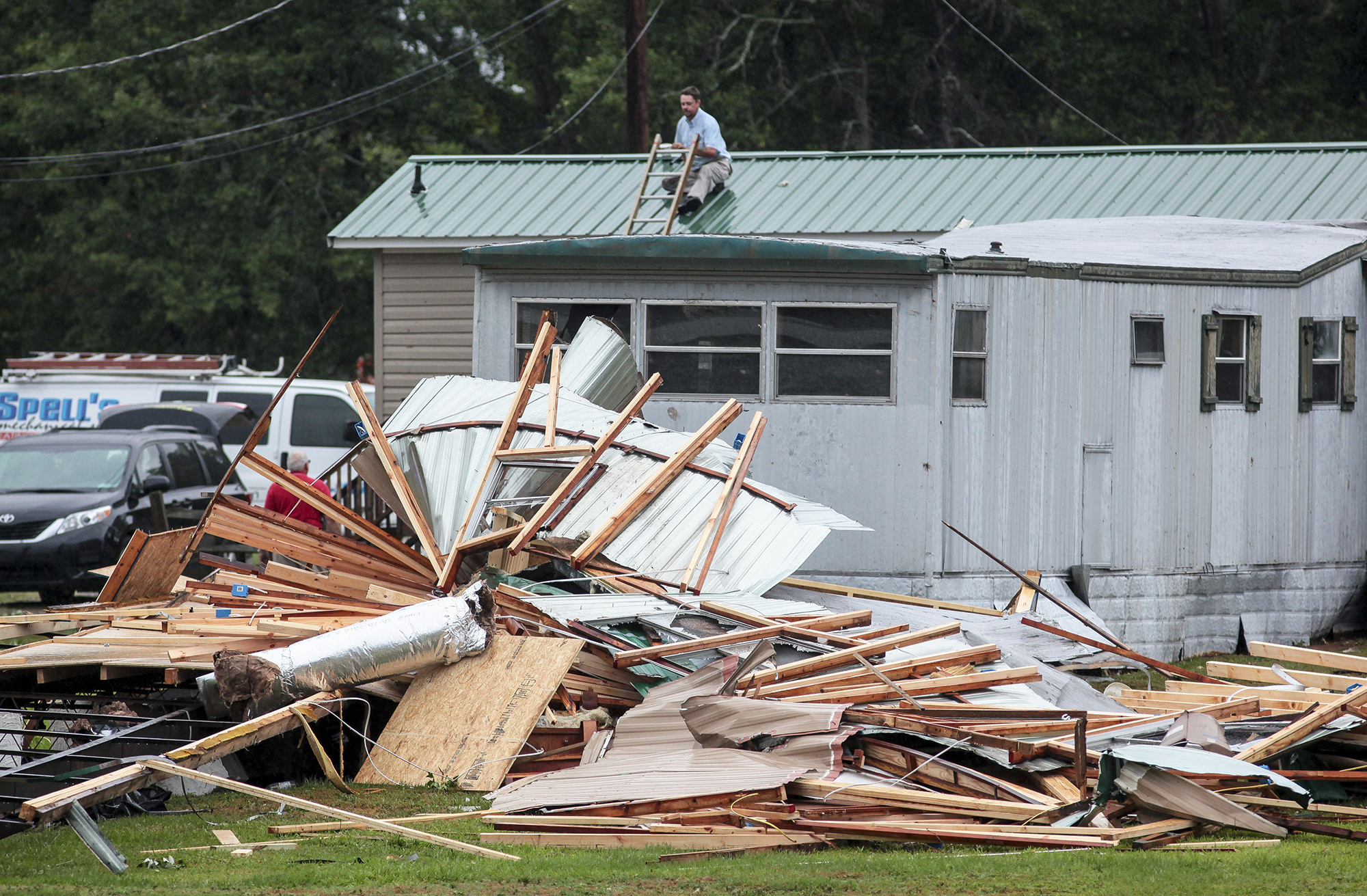A man patches holes in his roof after a possible tornado destroyed parts of a mobile home neighborhood and a volunteer fire station in Autryville, N.C., on May 23, 2017. (Raul Rubiera—AP)