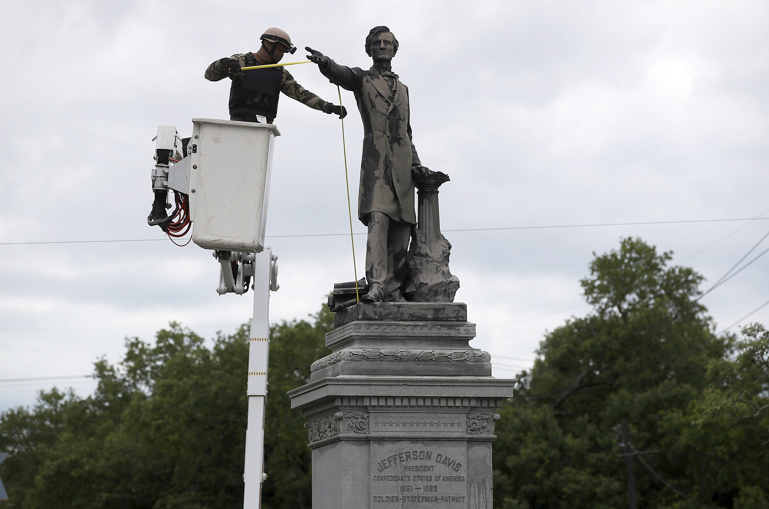 A worker in body armor measures New Orleans’ Jefferson Davis monument for removal (Justin Sullivan—Getty Images)
