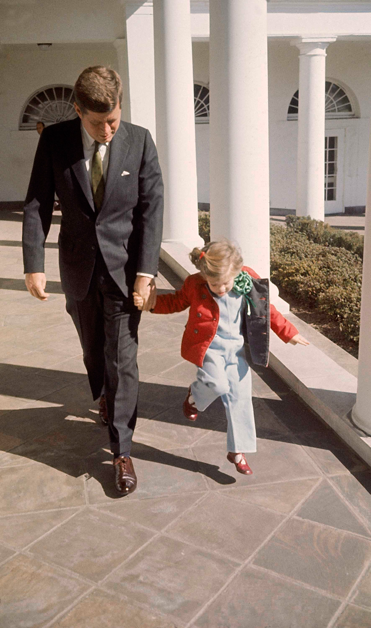 President Kennedy walks hand-in-hand with daughter Caroline on St. Patrick's Day at the White House, March 17, 1961.