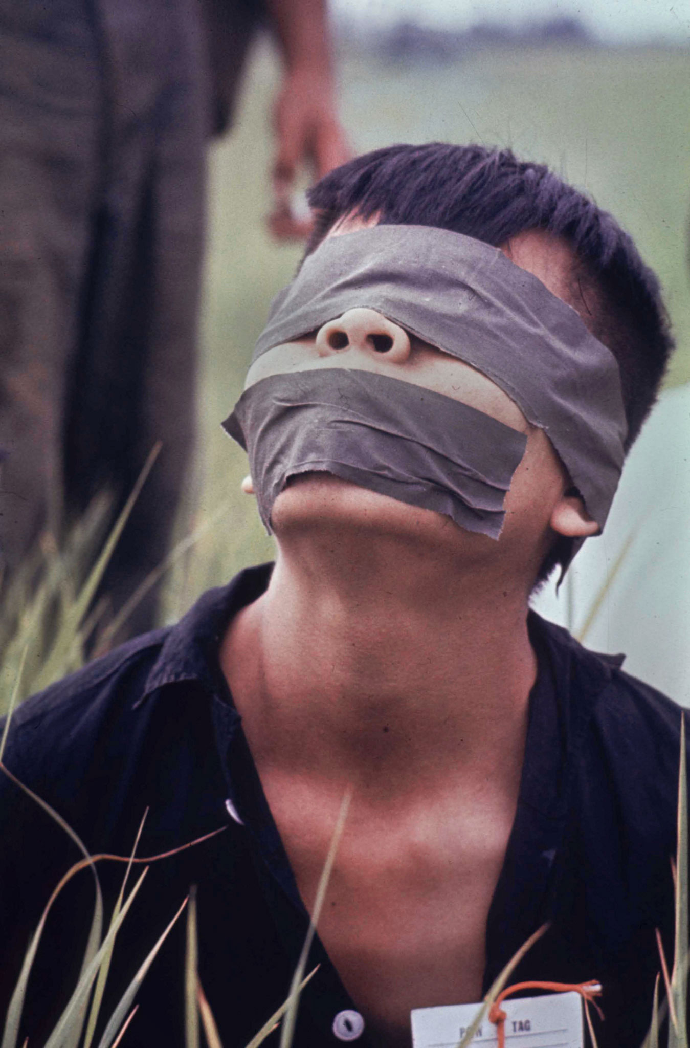 The eyes and mouth of a Vietcong prisoner are taped by U.S. Marines. This picture ran on the cover of Life's Nov. 26, 1965 issue with the cover line, "The Blunt Reality of War."