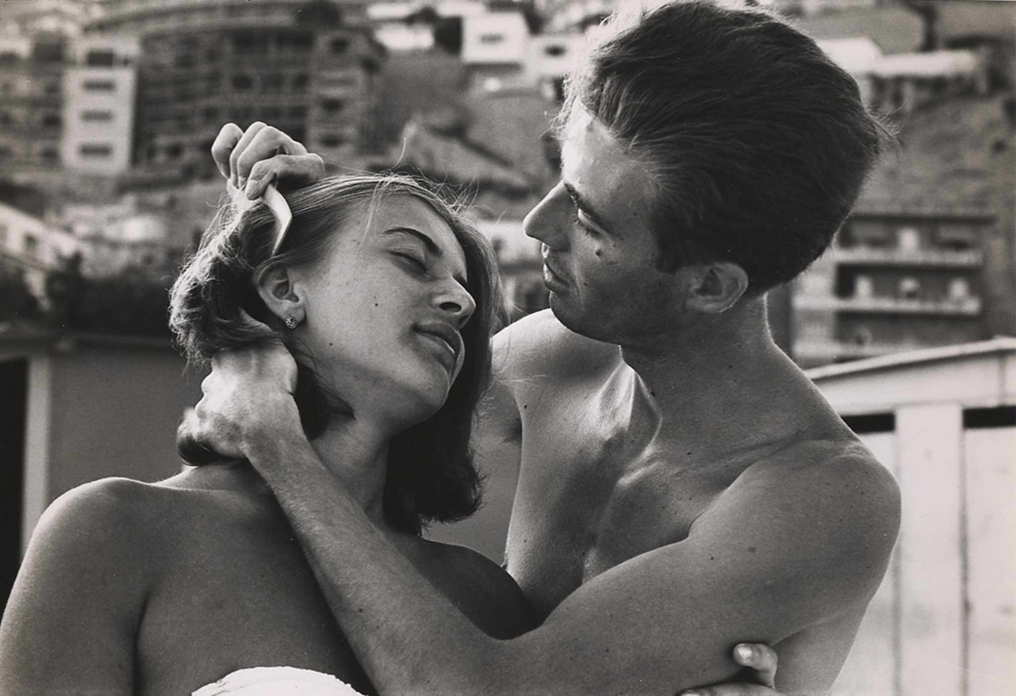 A man lovingly combs his girlfriend's hair, photographed for a photo essay entitled "The Italian Man," 1963.