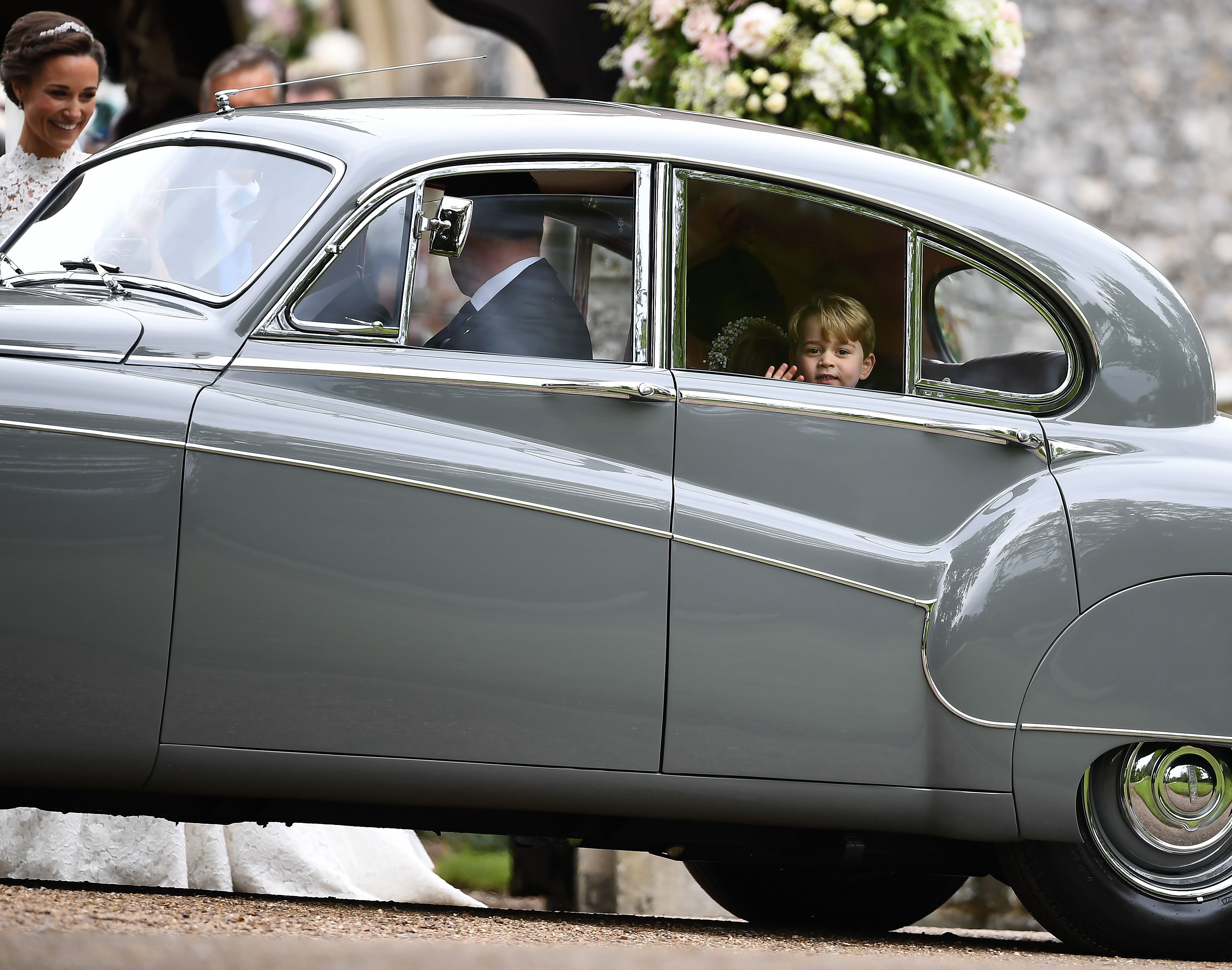 Britain's Prince George (R) waves as he leaves in a car after attending the wedding of his aunt, Pippa Middleton (L), to James Matthews at St Mark's Church in Englefield, west of London, on May 20, 2017.TALLIS/AFP/Getty Images)
