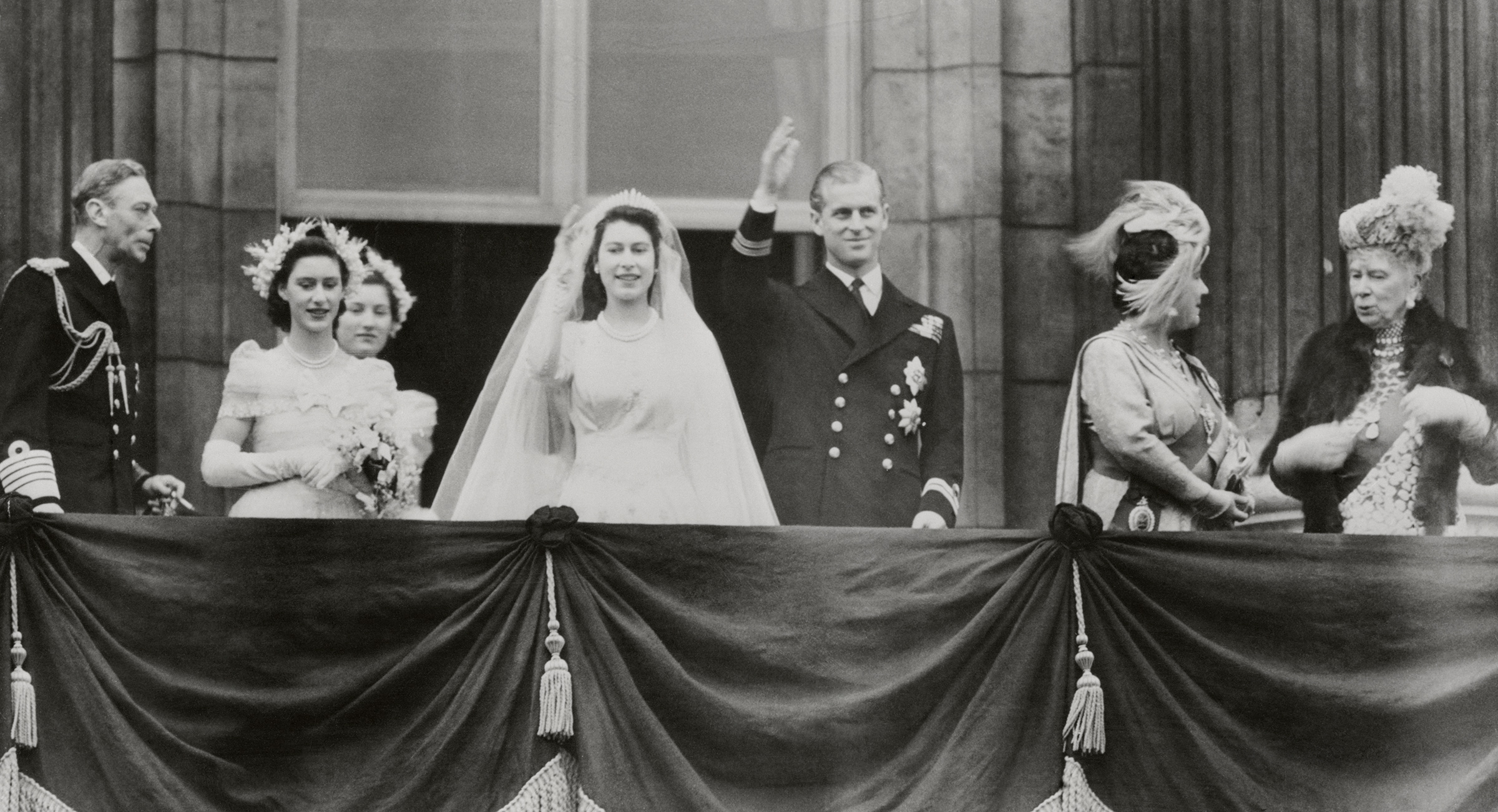 Princess Elizabeth and Philip Mountbatten, Duke of Edinburgh, wave from a balcony at Buckingham Palace in London, shortly after their wedding on Nov. 20, 1947. (Bettmann Archive/Getty Images)
