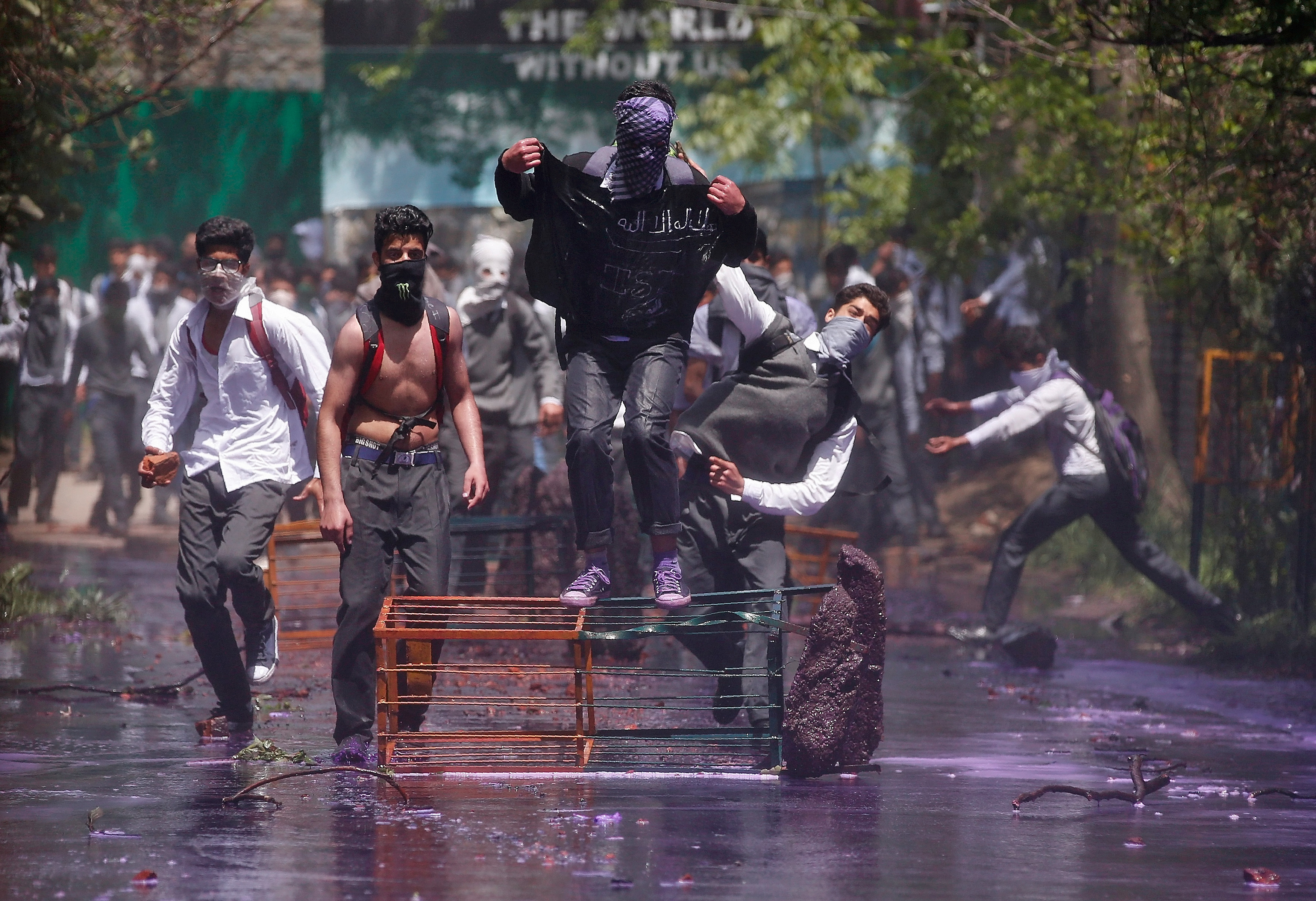 Kashmiri students shout slogans as they throw pieces of bricks and stones towards Indian policemen during a protest in Srinagar