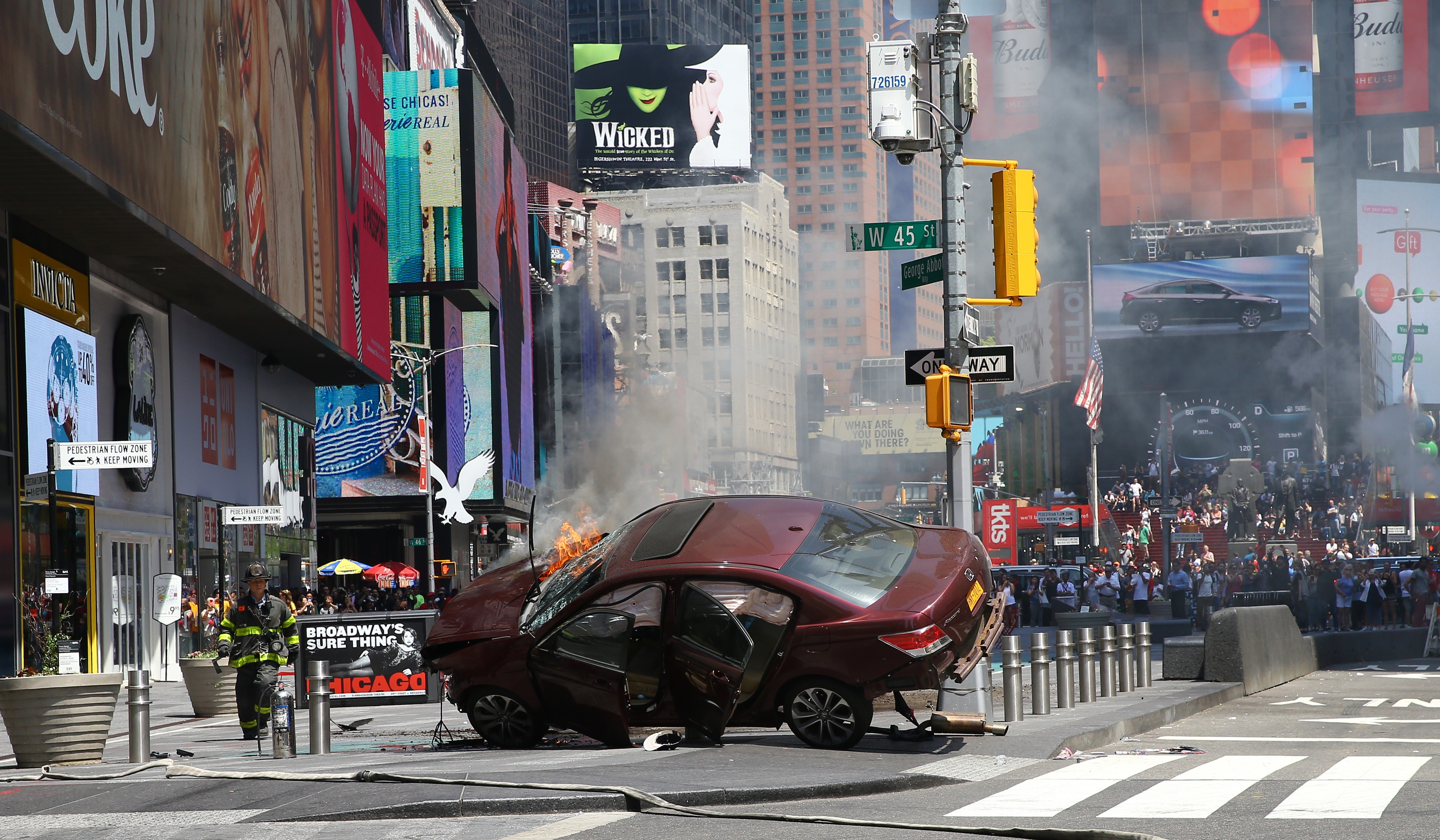 Flames and smoke rise from a wrecked vehicle after it plowed into pedestrians on a busy sidewalk on the corner of West 45th St. and Broadway at Times Square in New York on May 18, 2017. (Volkan Furuncu—Anadolu Agency/Getty Images)