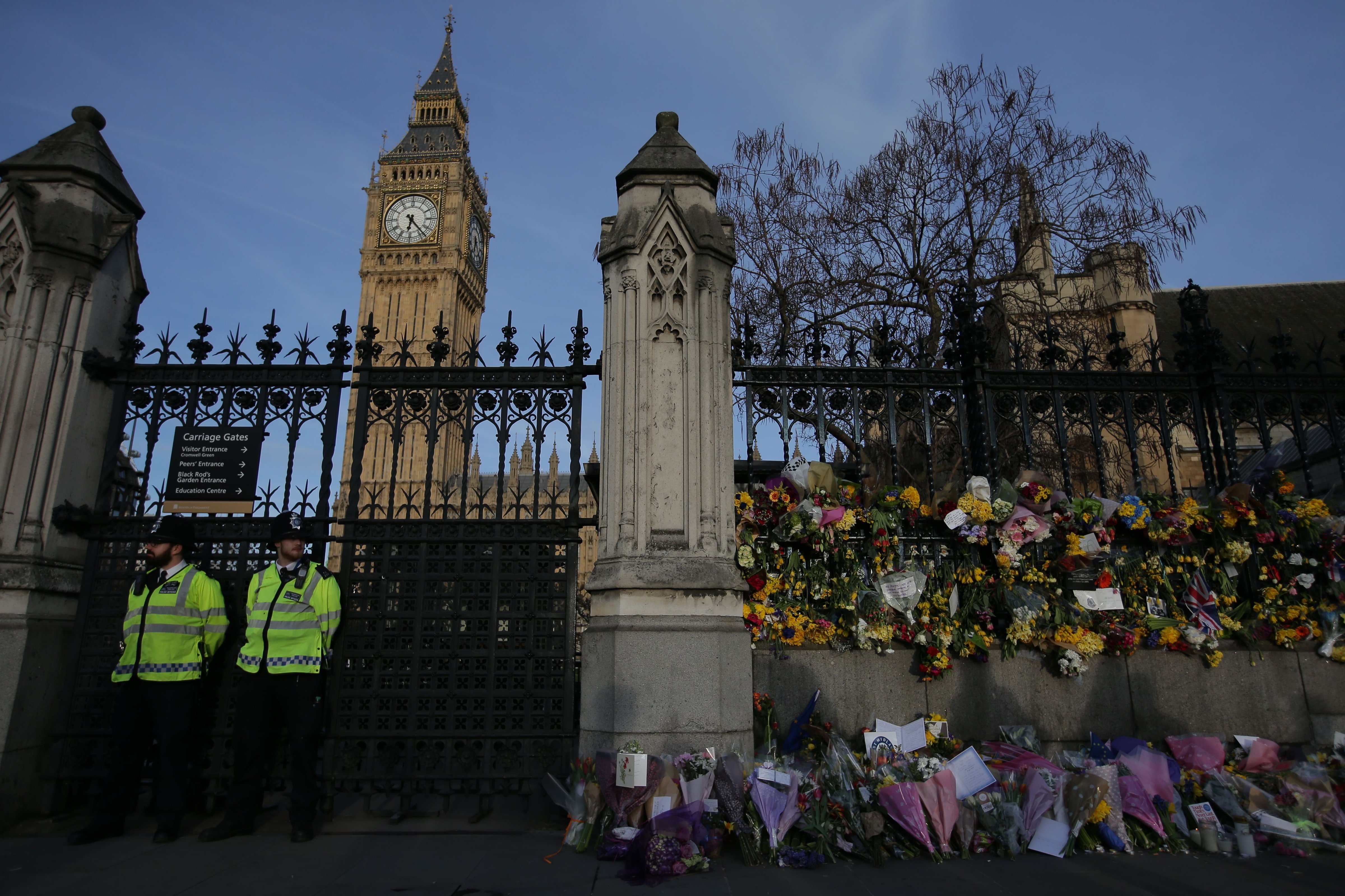 Police officers are seen with floral tributes to the victims of the March 22 terror attack in front of the Elizabeth Tower, more commonly referred to as 'Big Ben' in central London on March 26, 2017. (DANIEL LEAL-OLIVAS—AFP/Getty Images)