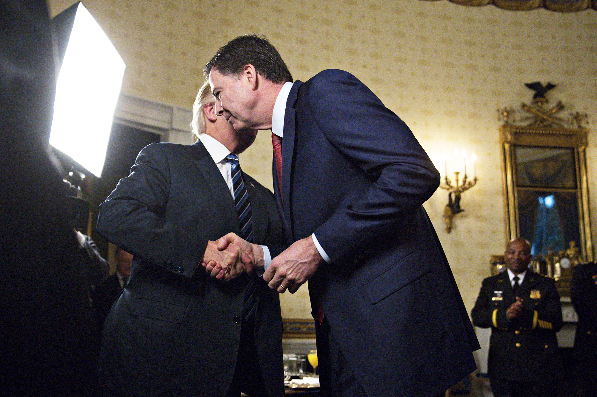 Donald Trump shakes hands while attempting to embrace former FBI Director James Comey in Washington, D.C., on Jan. 22, 2017.