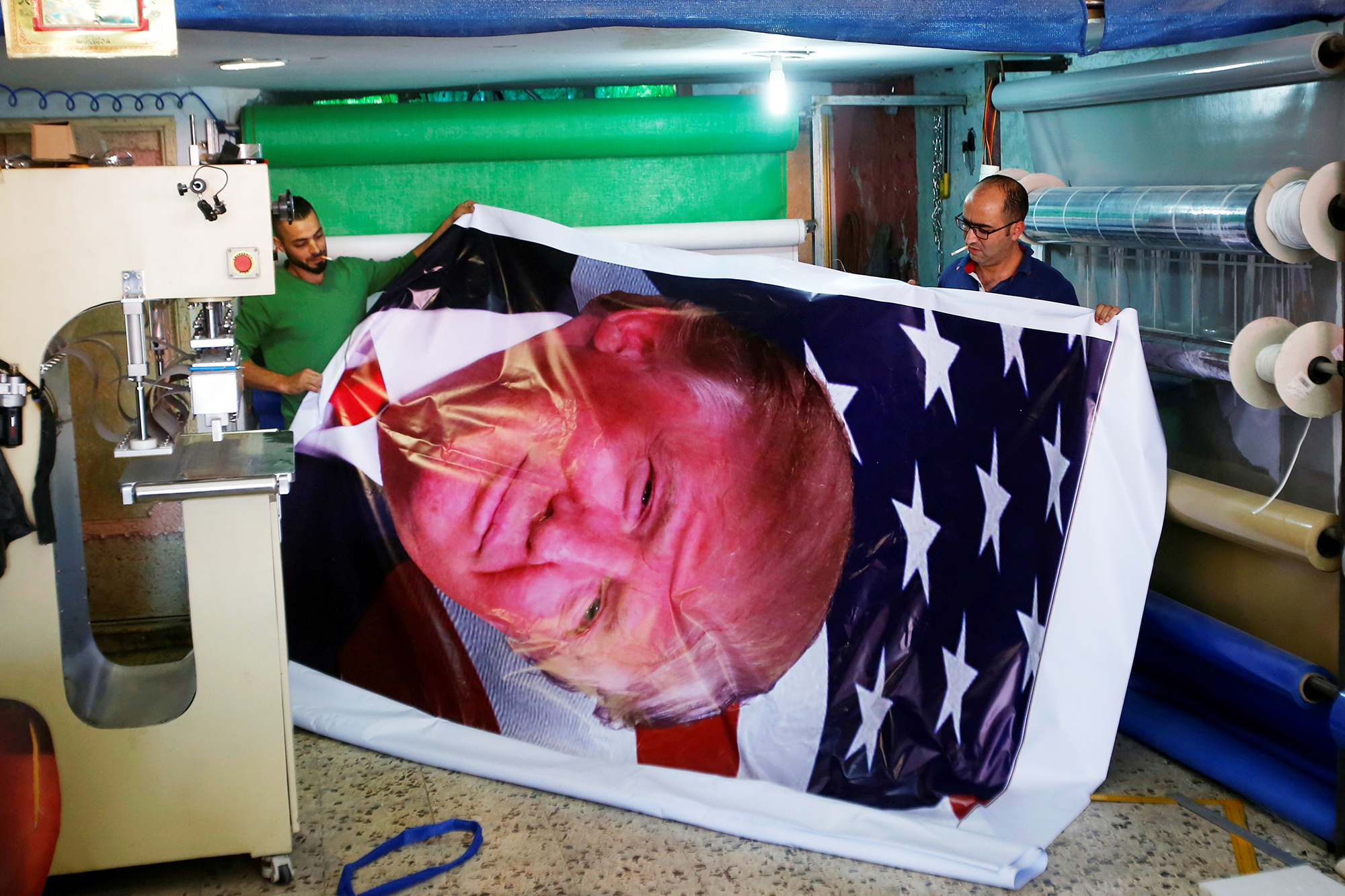 Palestinians print a poster depicting U.S. President Trump in preparations for his planned visit, in the West Bank town of Bethlehem