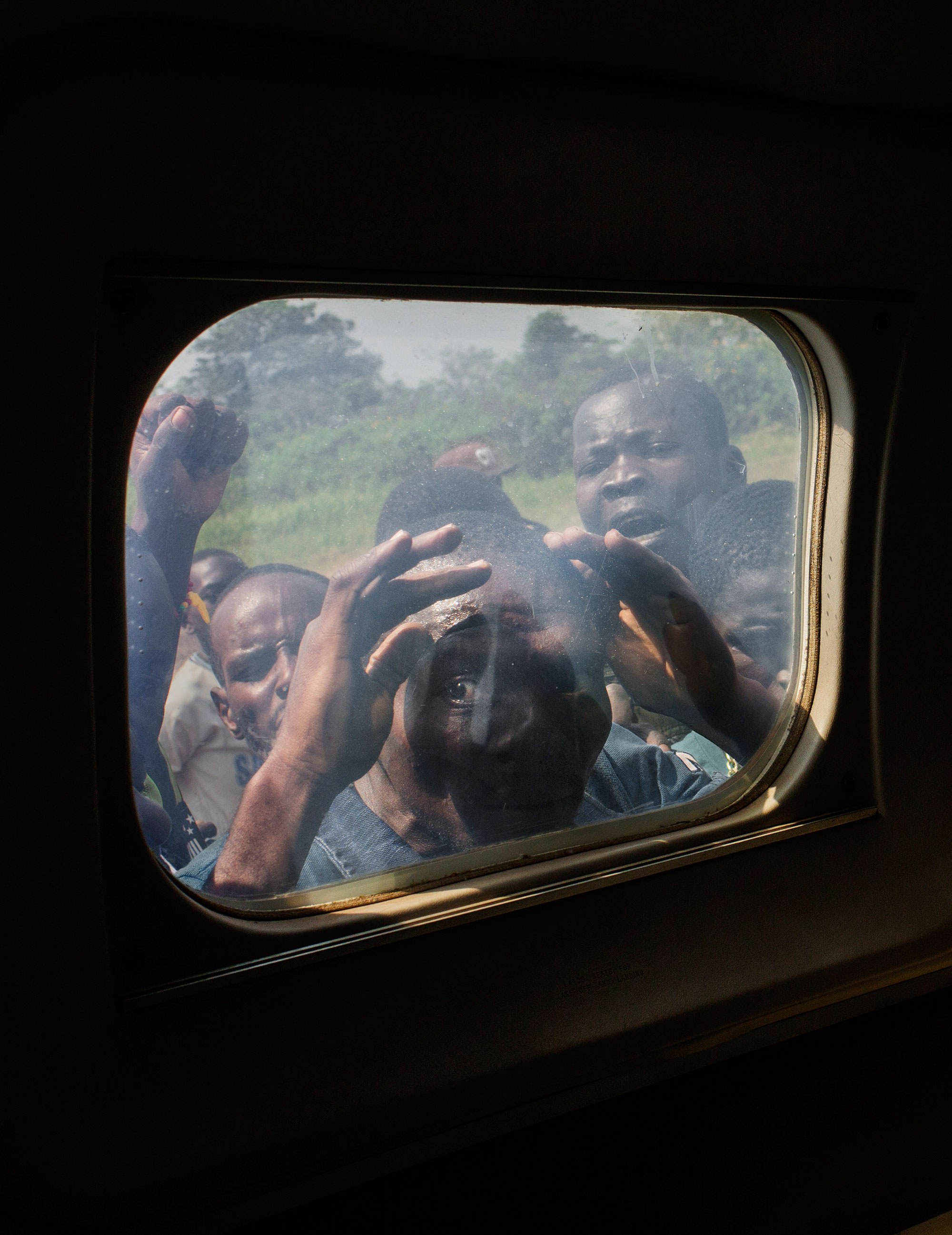 A man looks through the window of the plane of presidential candidate Karim Meckassoua. He complains that he has not been paid for his work during a political meeting in the town of Carnot.