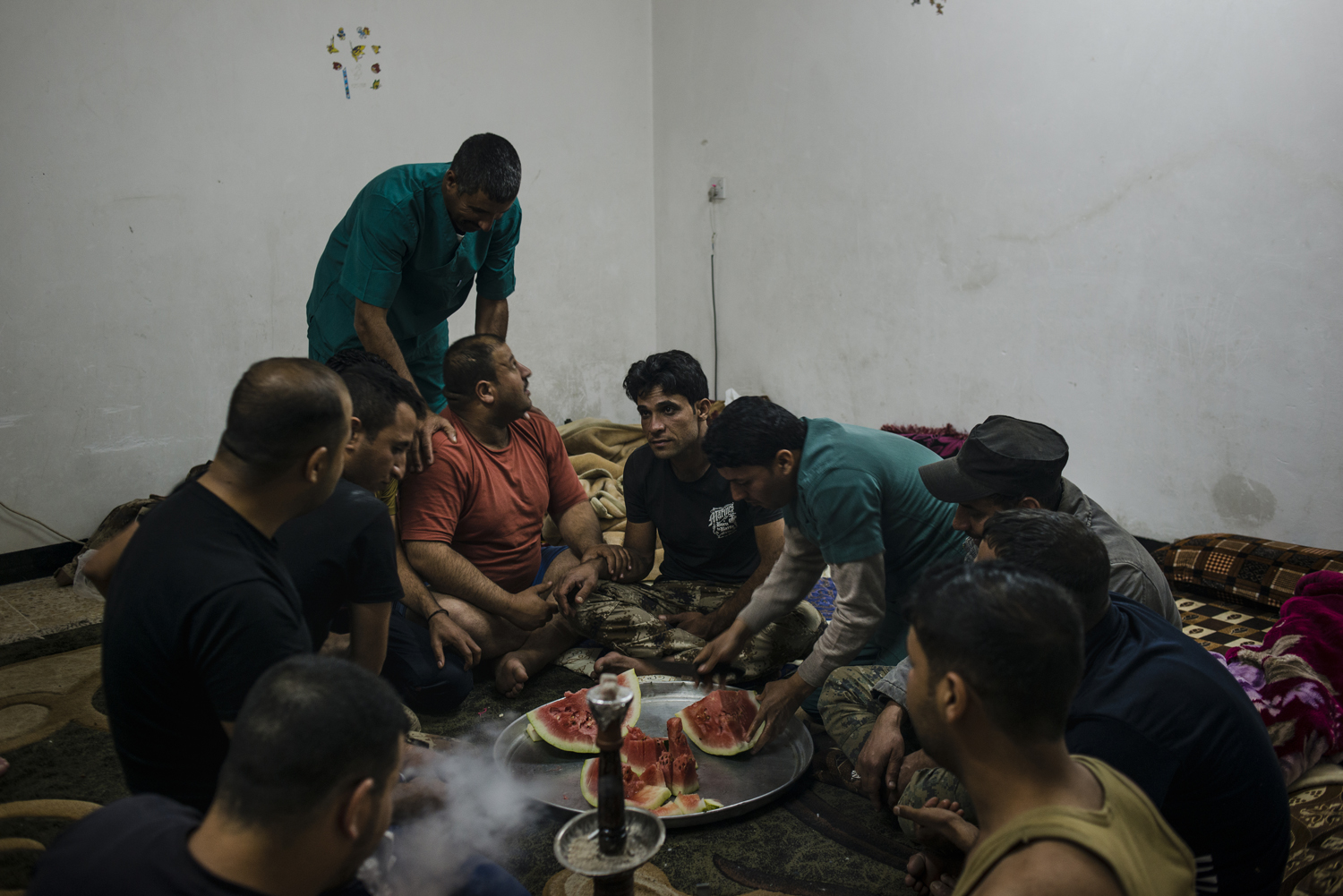 Ahmad (center) tries to resist laughing while the rest of the ISOF medics joke around after a long day of treating the wounded during the battle for Mosul, Iraq, on April 18, 2017. (Alex Potter)