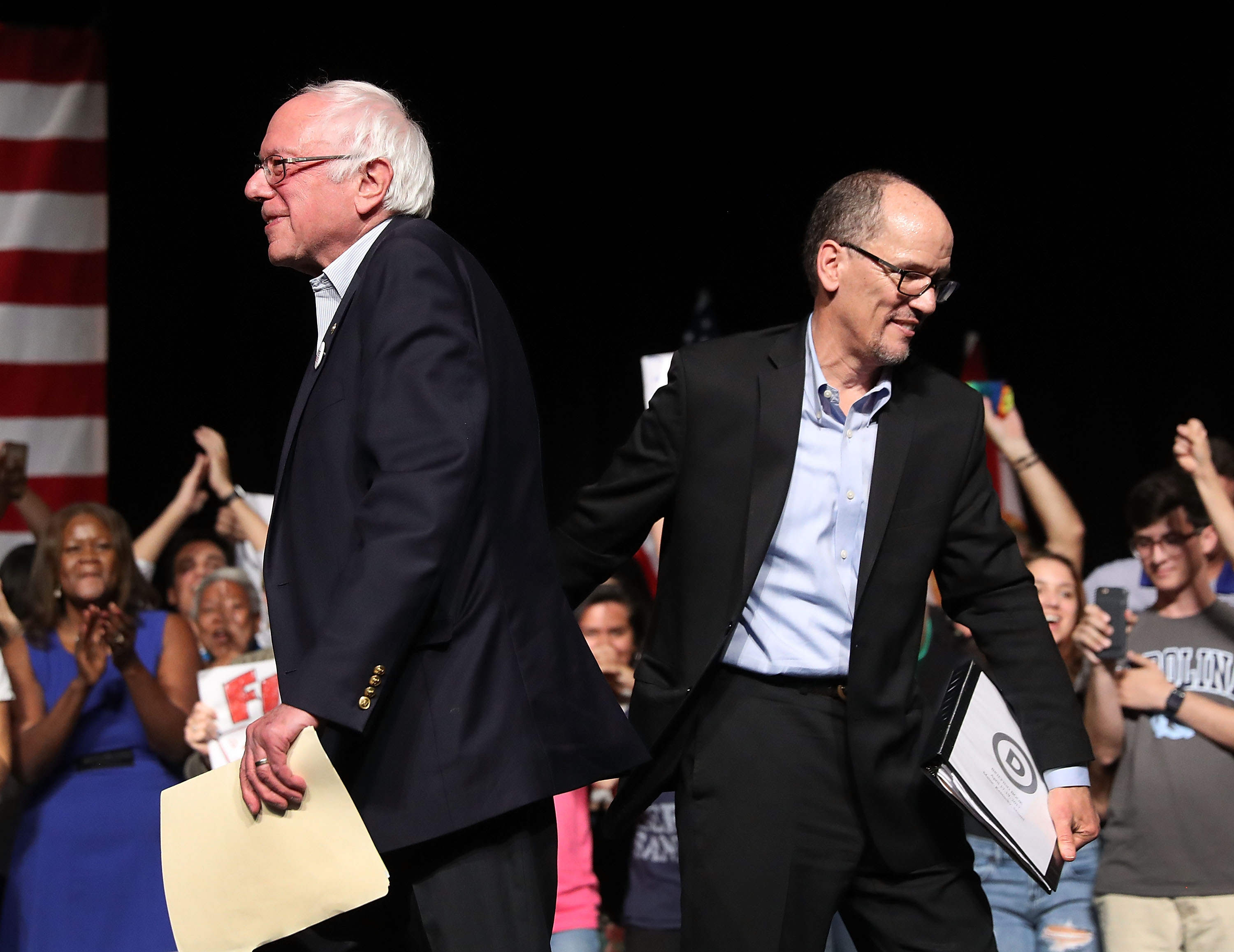Sen. Bernie Sanders (I-VT) and DNC Chair Tom Perez walk past each other as Sen. Sanders takes to the stage to speak during their "Come Together and Fight Back" tour at the James L Knight Center on April 19, 2017 in Miami, Florida. (Joe Raedle&mdash;Getty Images)