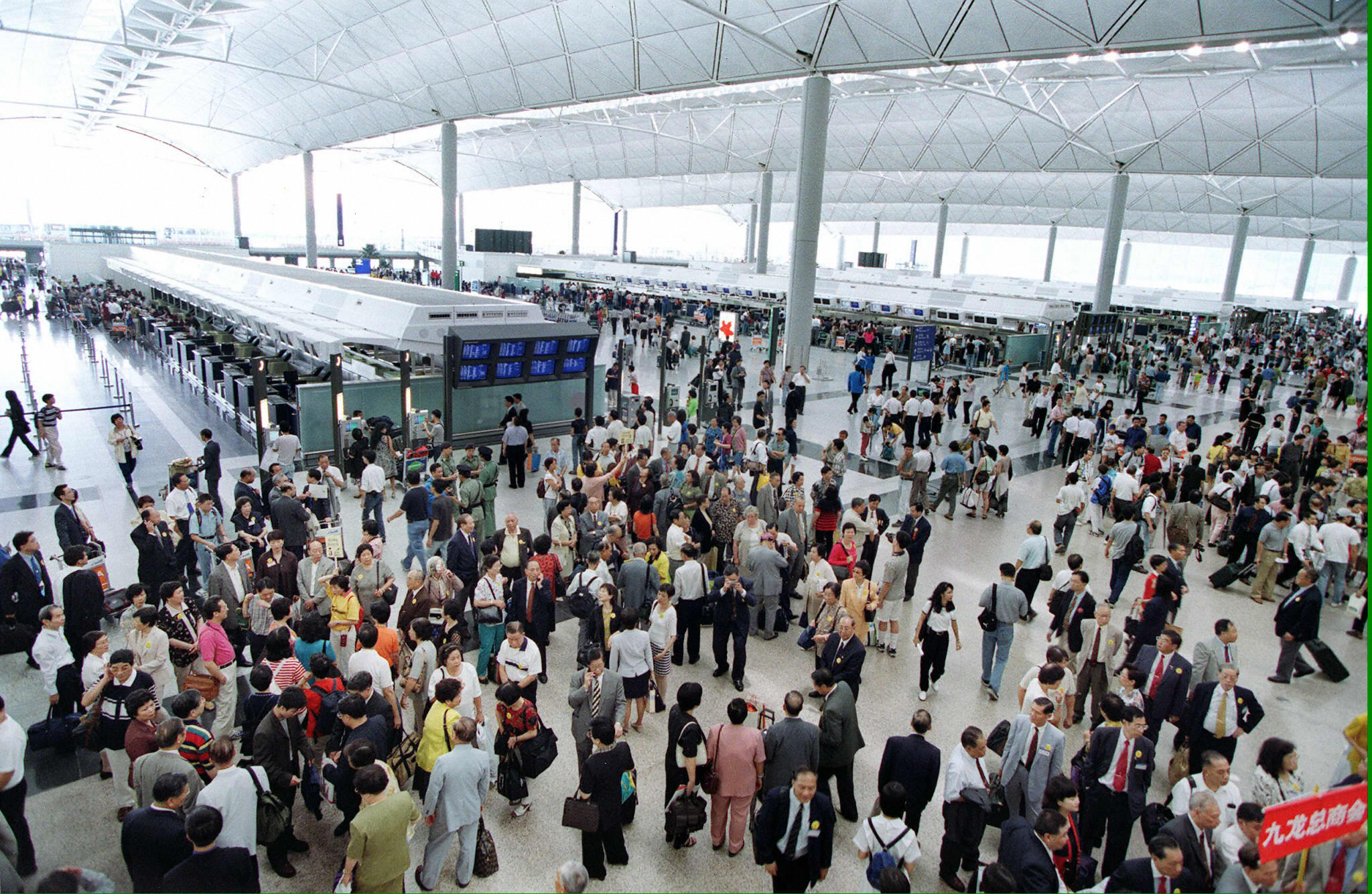 People crowd near the check-in counters at the departure level of the state-of-the-art Chek Lap Kok airport on July 6, 1998.
