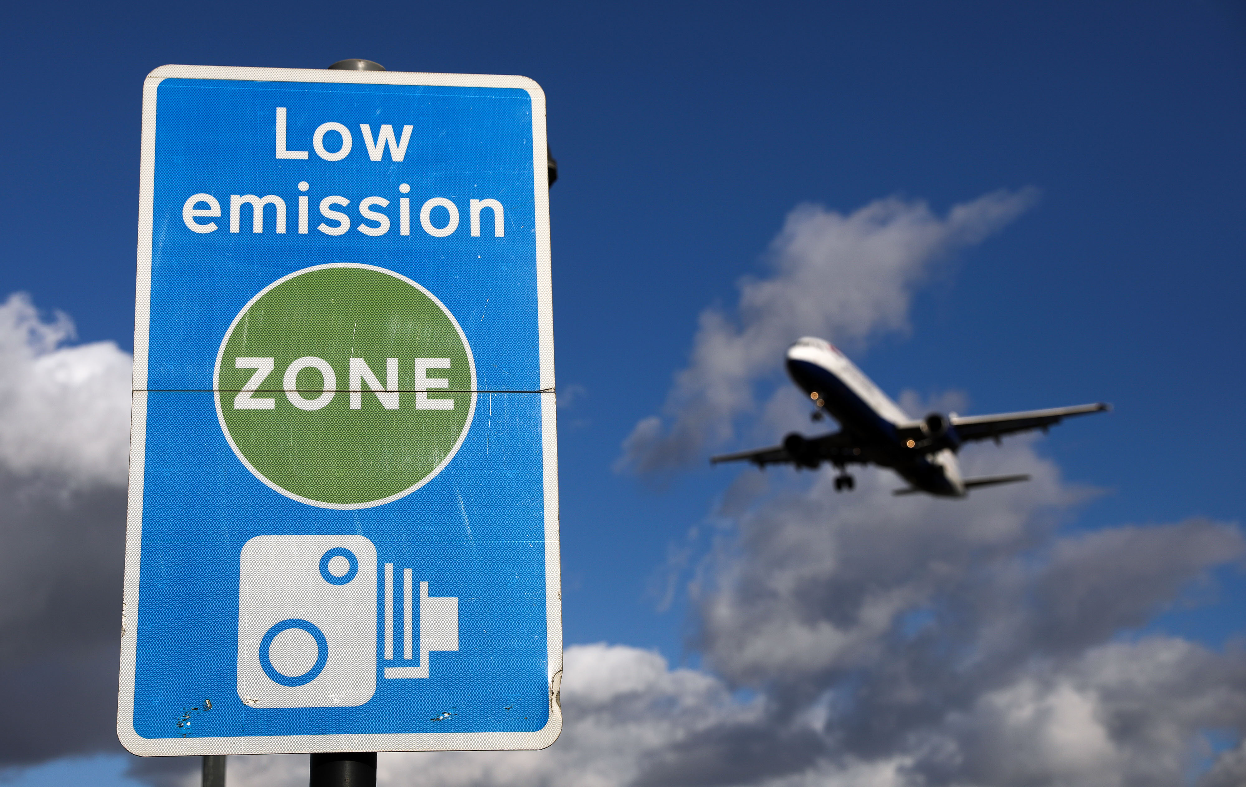 An aircraft operated by British Airways passes a low emission zone sign as it prepares to land at Heathrow airport, in London in October. (Bloomberg—Bloomberg via Getty Images)