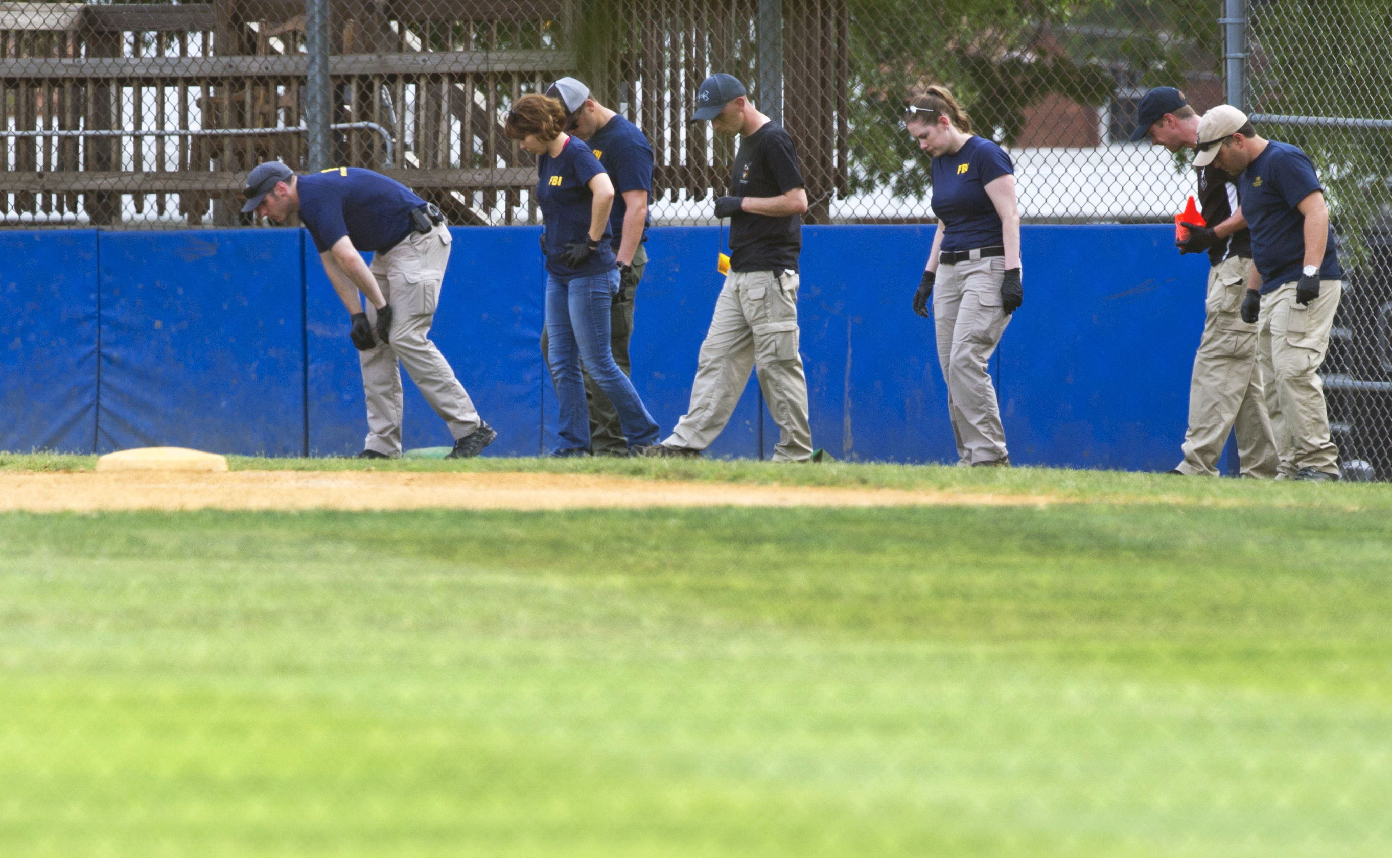The FBI Evidence Response Team inspects the third base side of the baseball field in Alexandria, Va., June 14, 2017, where a rifle-wielding attacker opened fire on Republican lawmakers at a congressional baseball practice. (Cliff Owen—AP)