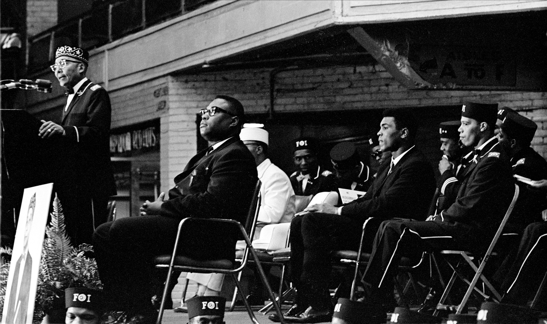 Elijah Muhammad speaks during Saviour's Day celebrations, while Muhammad Ali listens (center, fore), at the International Ampitheatre, Chicago, IL, on Feb. 27, 1966. (Robert Abbott Sengstacke—Getty Images)