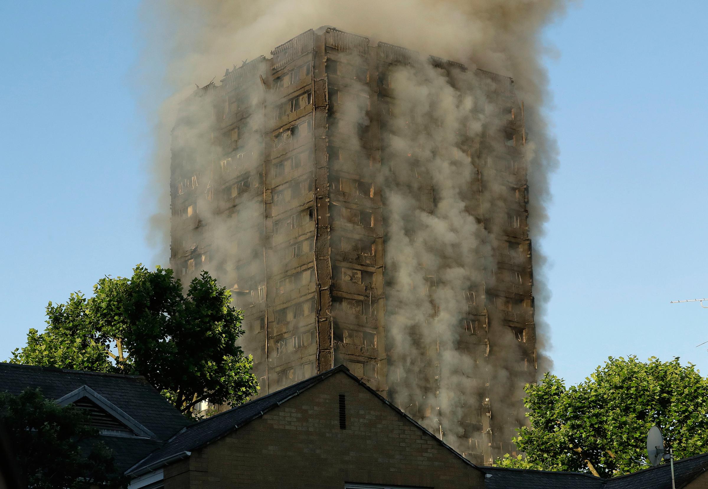 Smoke rises from a high-rise building that caught fire overnight in West London on June 14, 2017.