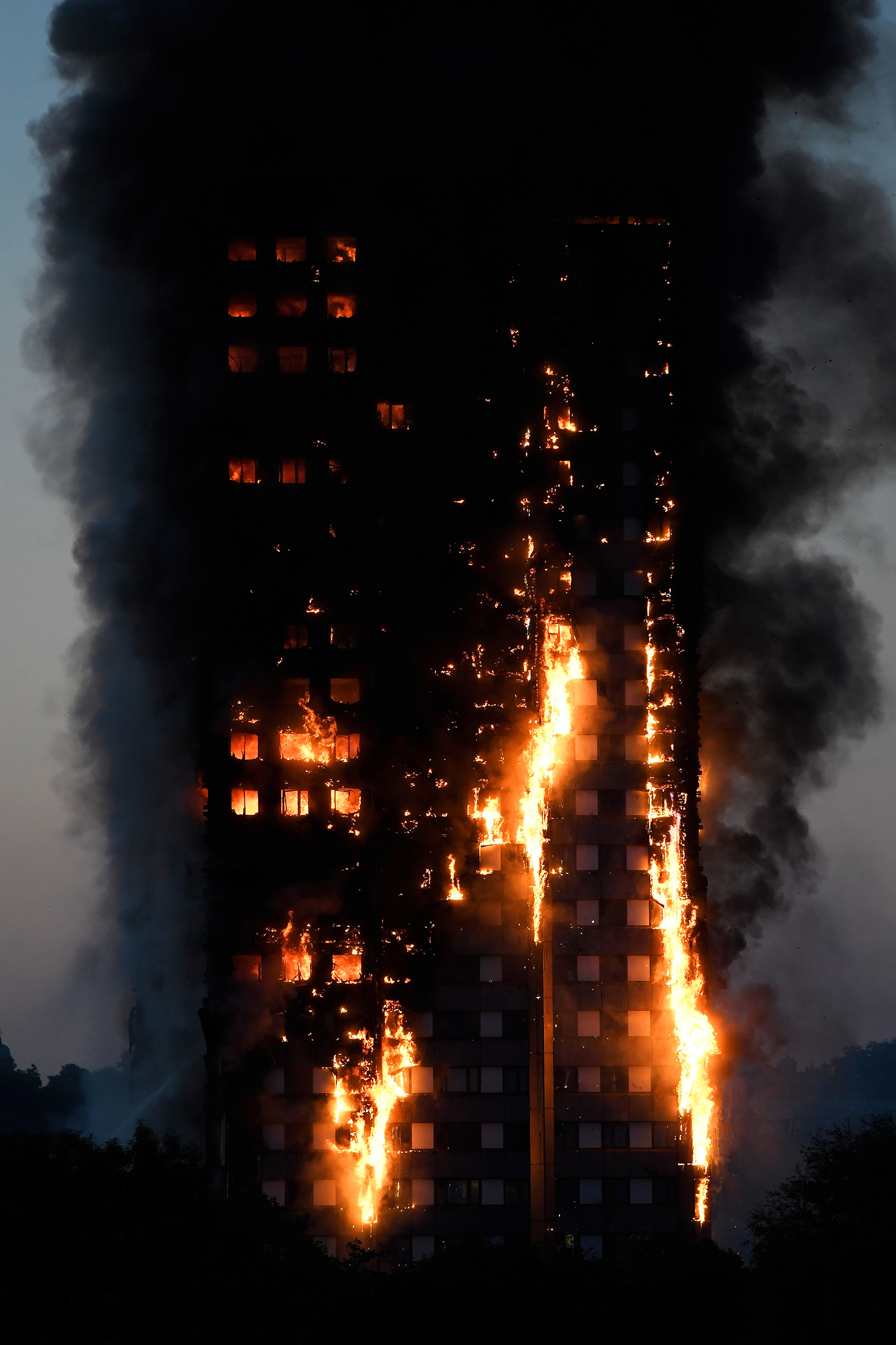Flames and smoke billow as firefighters deal with a serious fire in a tower block at Latimer Road in West London on June 14, 2017.