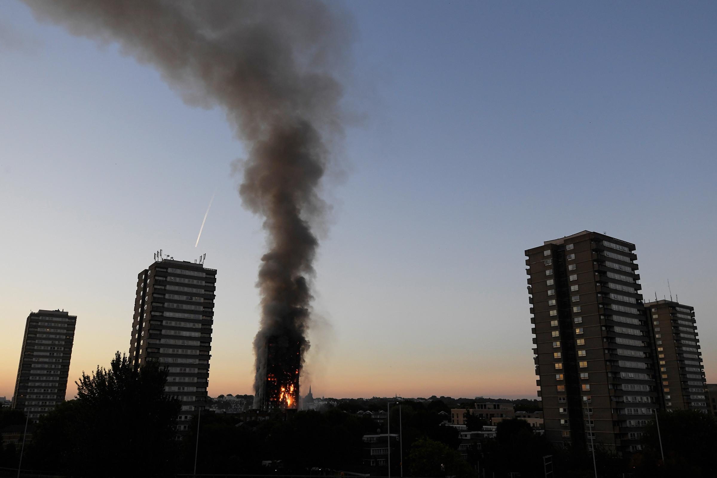 Flames and smoke billow as firefighters deal with a serious fire in a tower block at Latimer Road in West London on June 14, 2017.