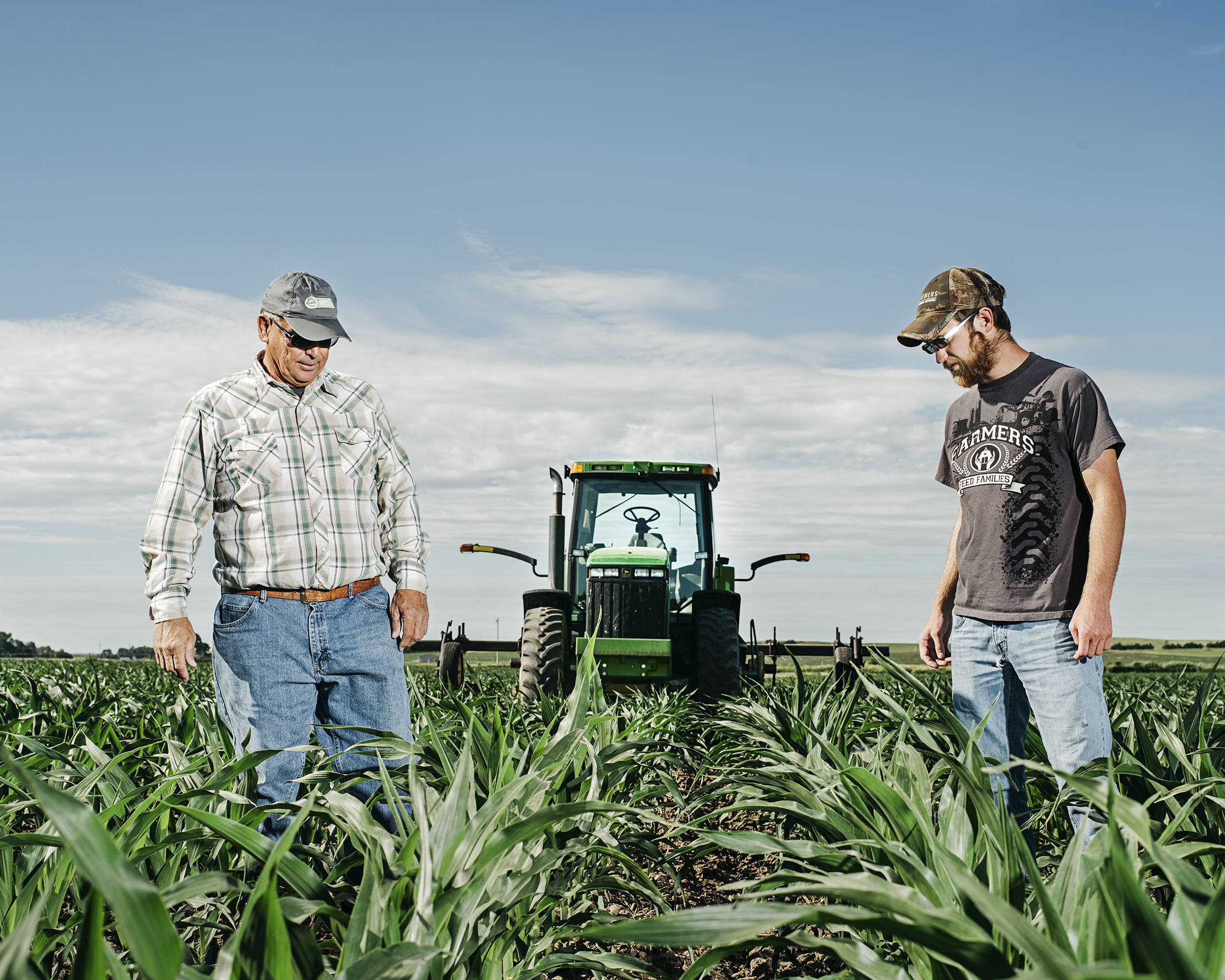 Guy Mills and his son James examine soil depth while hilling a cornfield with a John Deere tractor outside of Ansley, Neb., on June 19 (Photograph by Benjamin Rasmussen for TIME)
