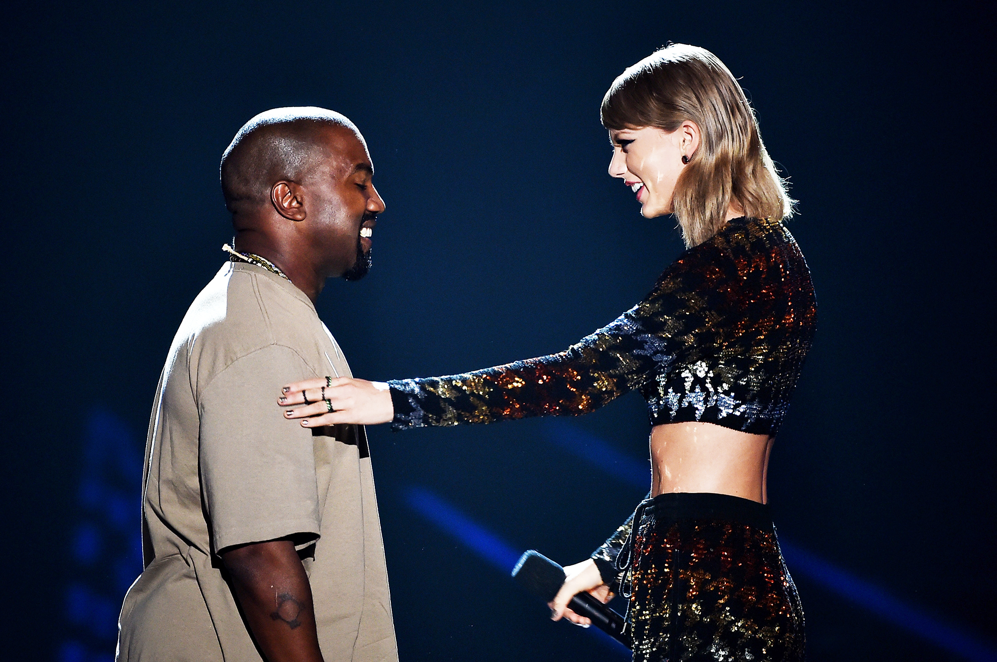 Kanye West, left, accepts the Video Vanguard Award from Taylor Swift onstage during the 2015 MTV VMAs in Los Angeles, on Aug. 30, 2015.