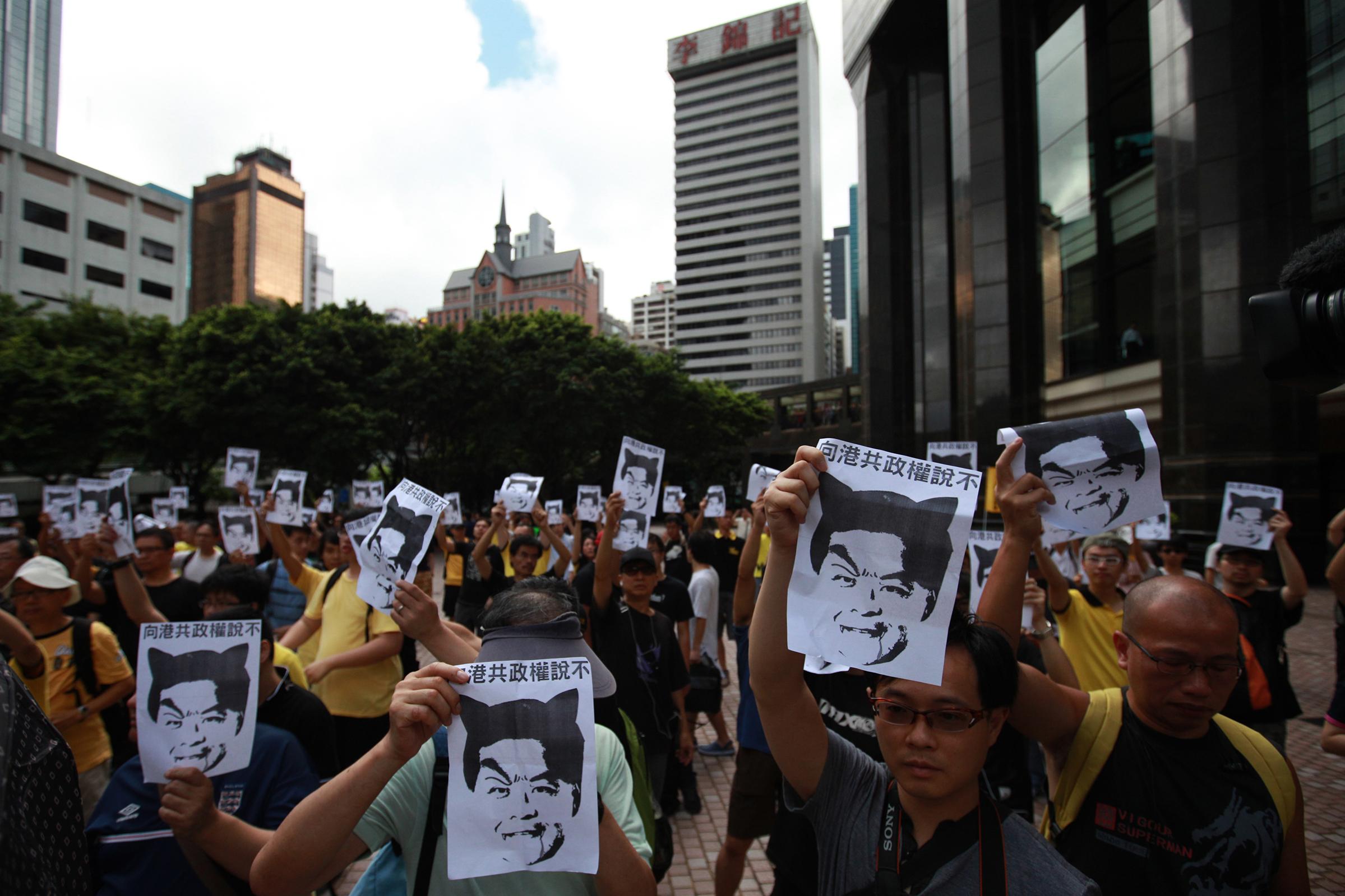 Protesters hold up pictures of Hong Kong Chief Executive-elect Leung Chun-ying during a protest against Leung in Hong Kong on July 1, 2012. Hong Kong installs a new leader and marks 15 years of Chinese rule, at a time of strong anti-Beijing sentiment after Hu was targeted by angry protesters.