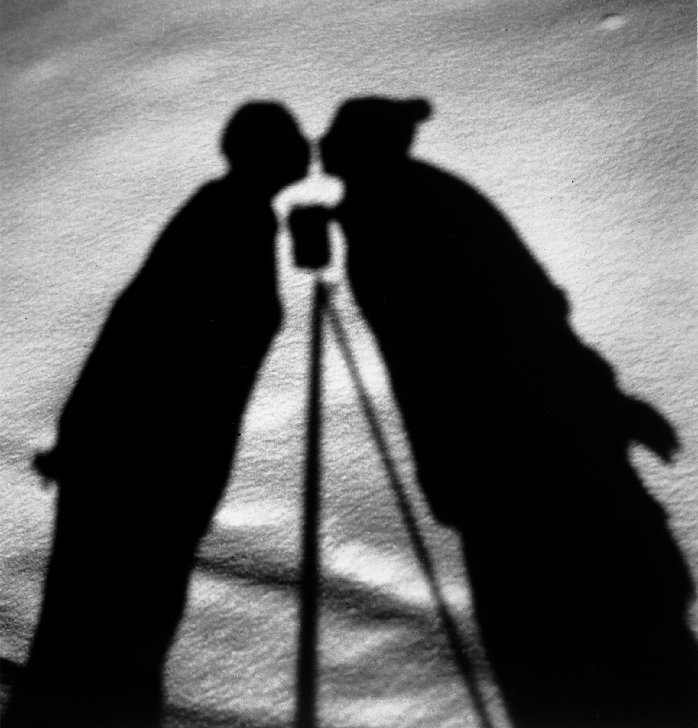 Shadows on the ground of kissing figures with camera on tripod between, 1930.