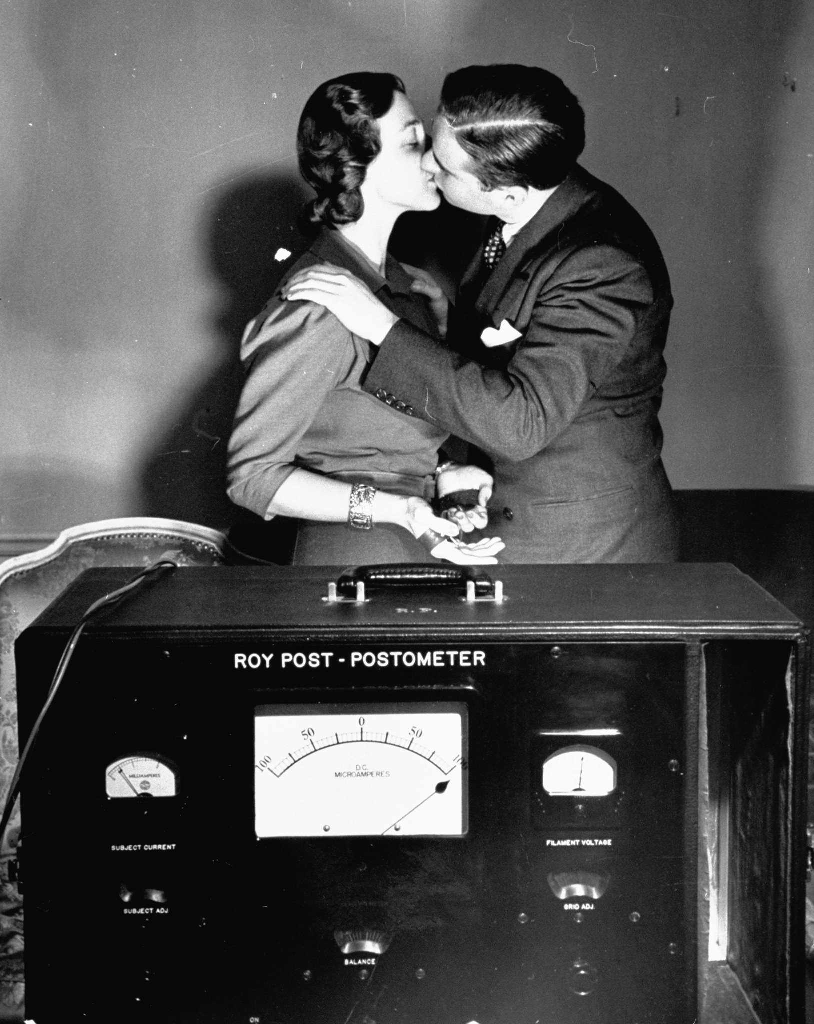 A man and woman kissing while geared to a lie detector machine to measure the emotional reaction,1939.