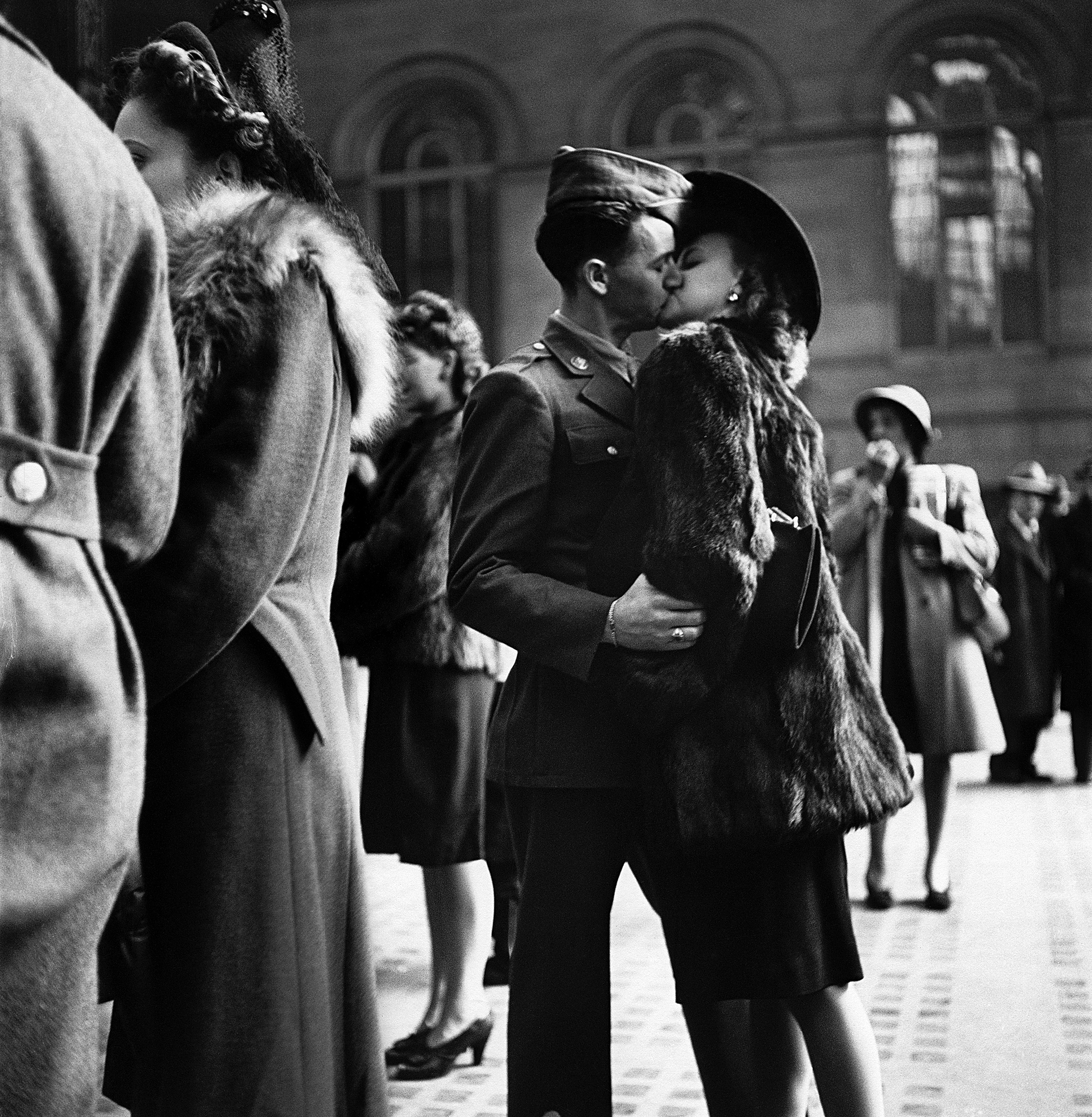 Couple in Penn Station sharing farewell kiss before he ships off to war during WWII. 1943.
