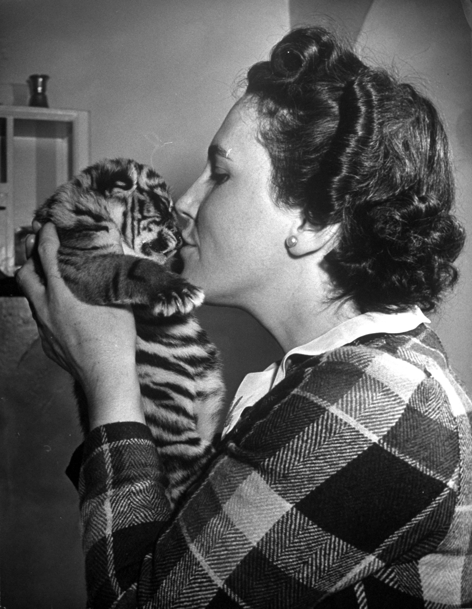 Mrs. Martini, wife of the Bronx Zoo lion keeper, kissing a tiger cub. 1944.