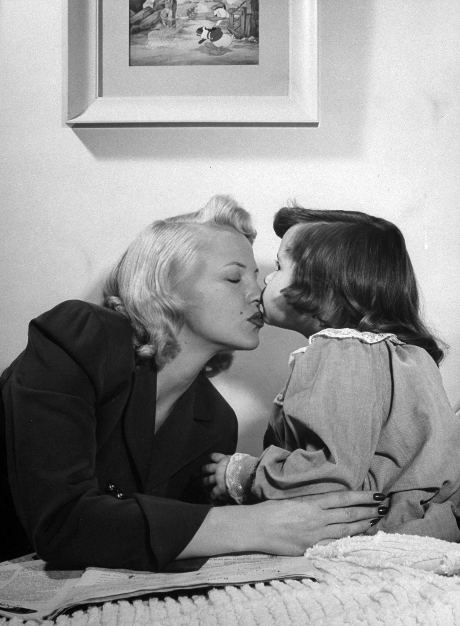 Peggy Lee getting a goodnight kiss on the nose from her 4-year-old daughter Nicki at home. 1948.