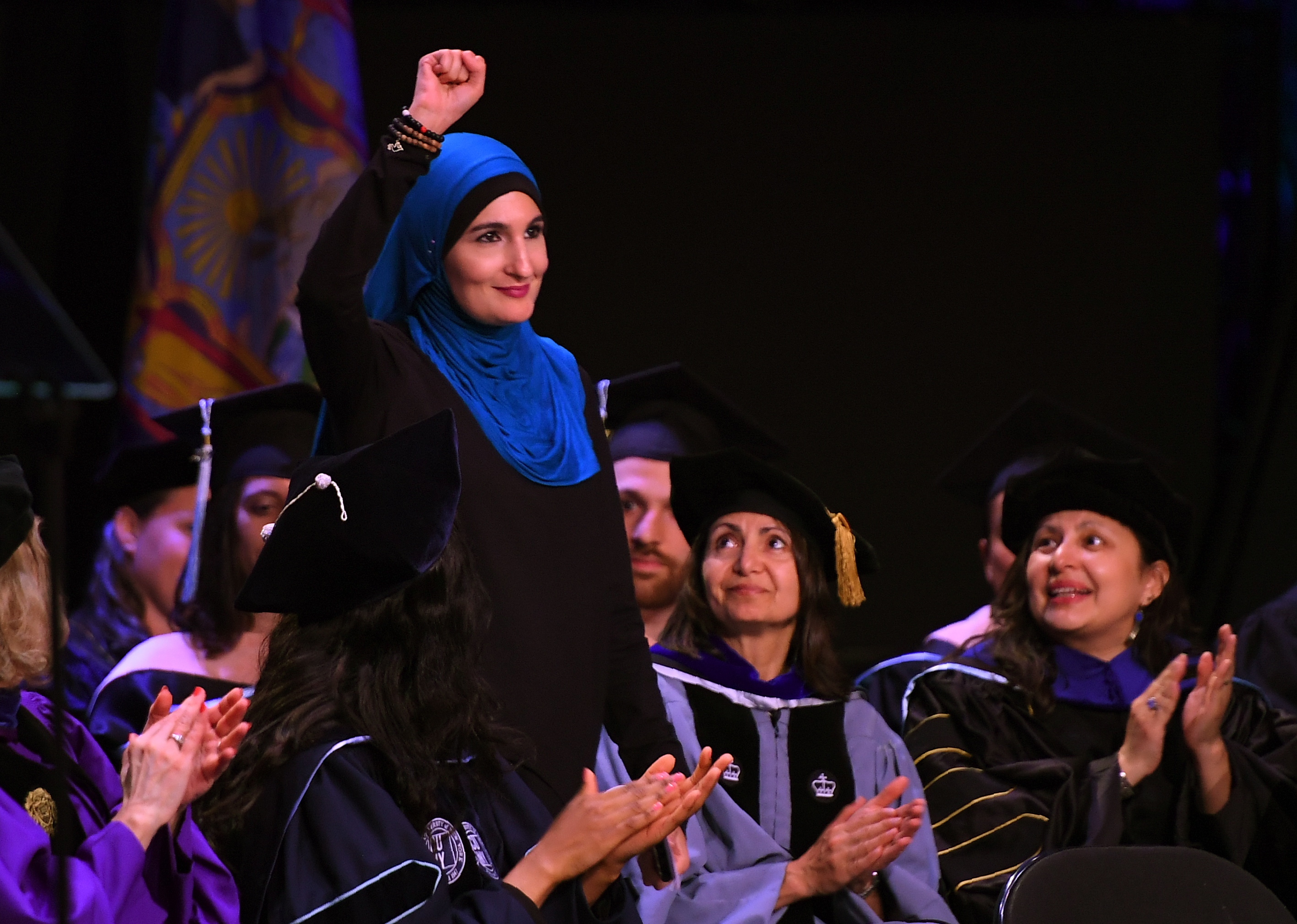 Linda Sarsour, co-organizer of the National Women's March, raises her fist as she walks to the stage to deliver the keynote address at the CUNY School of Public Health commencement ceremony on June 1, 2017 at the Apollo Theatre in Harlem. (Timothy A. Clary—AFP/Getty Images)