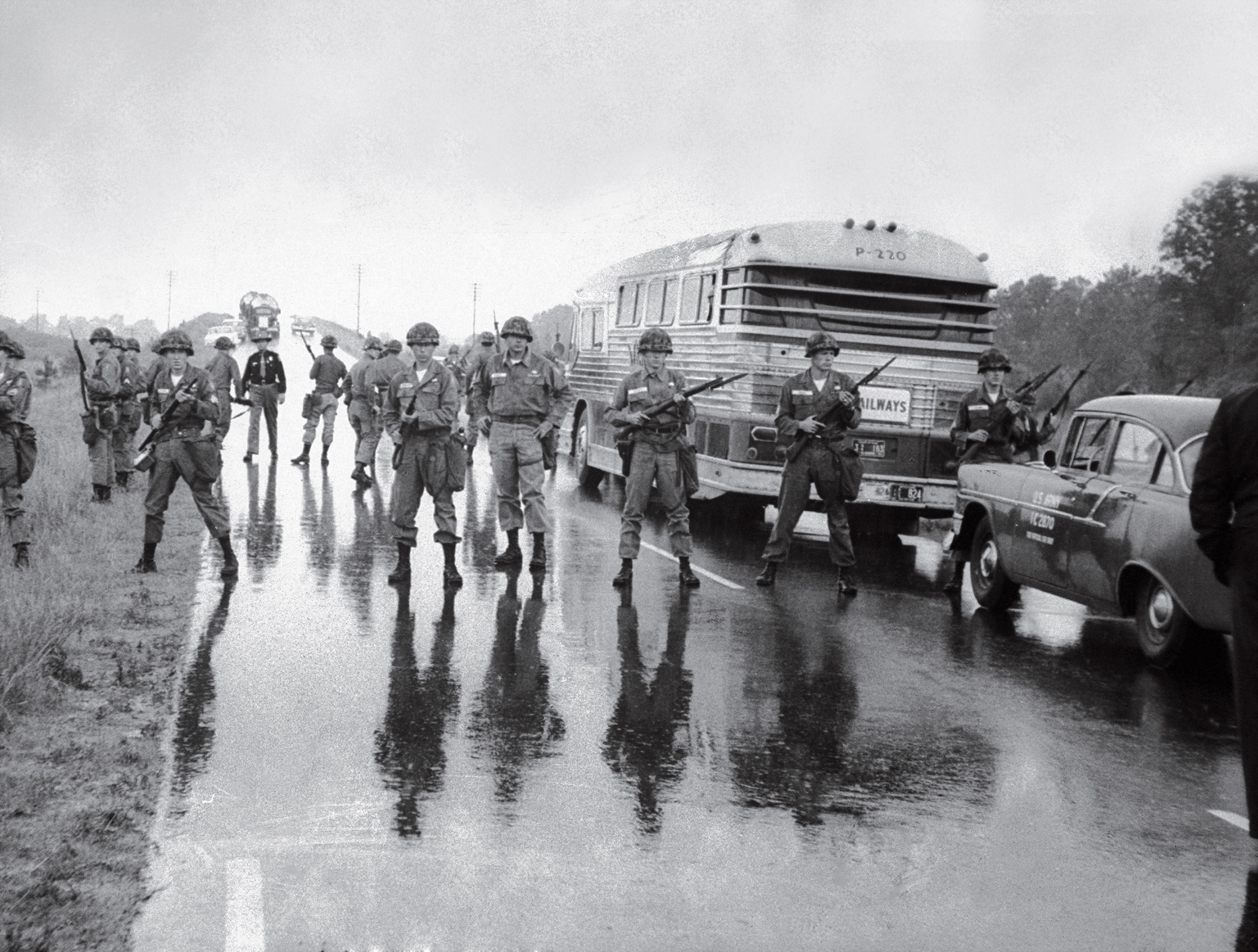 Near the Mississippi-Alabama border, members of the Alabama National Guard surround a bus carrying freedom riders, May 1961.