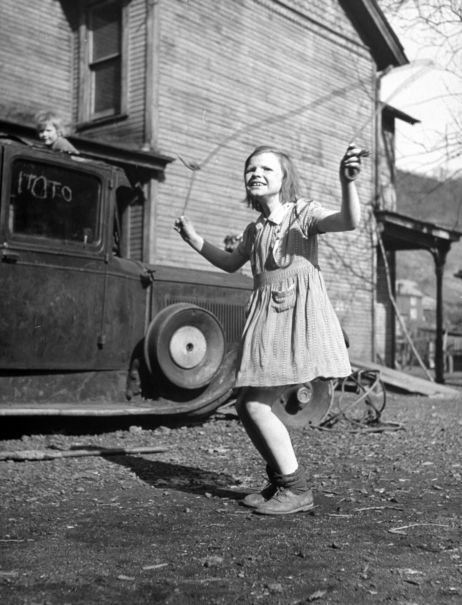 A little girl playing in her front yard in the slum area of Pittsburgh.