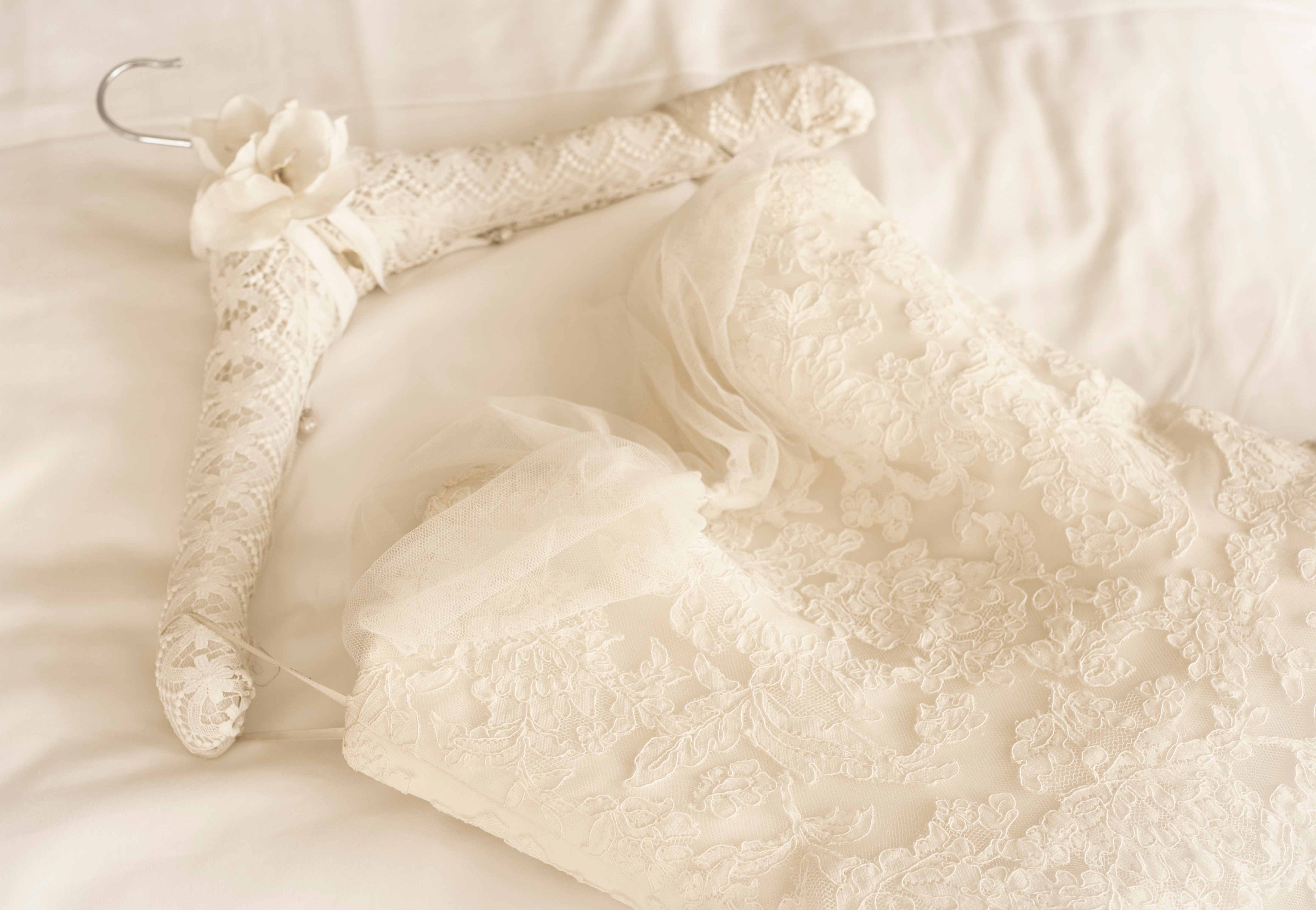 Germany, Lace wedding dress lying on bed