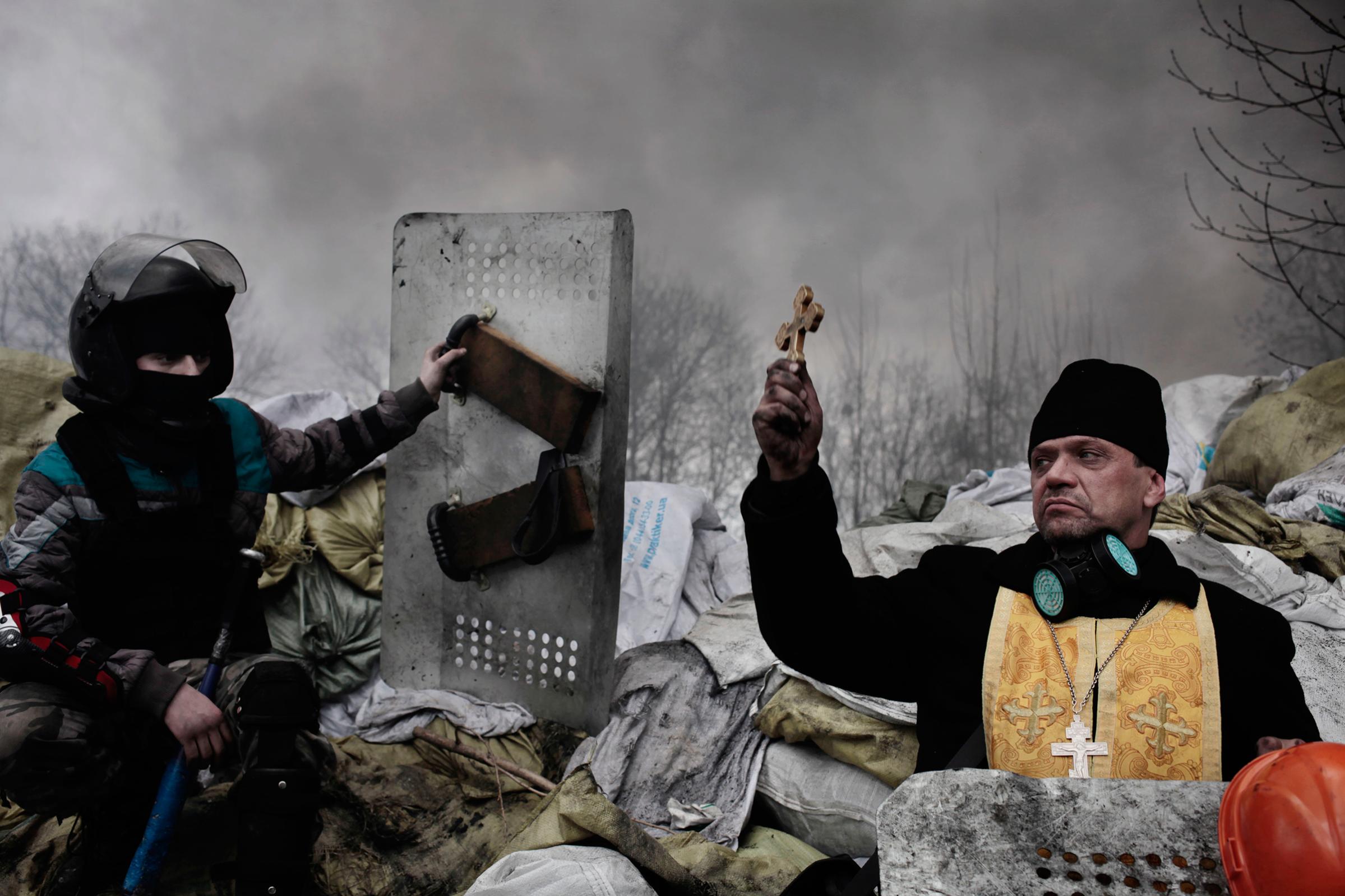 protest-ukraine-kiev-orthodox-priest-blesses-protesters-riot-police-jerome-sessini-magnum