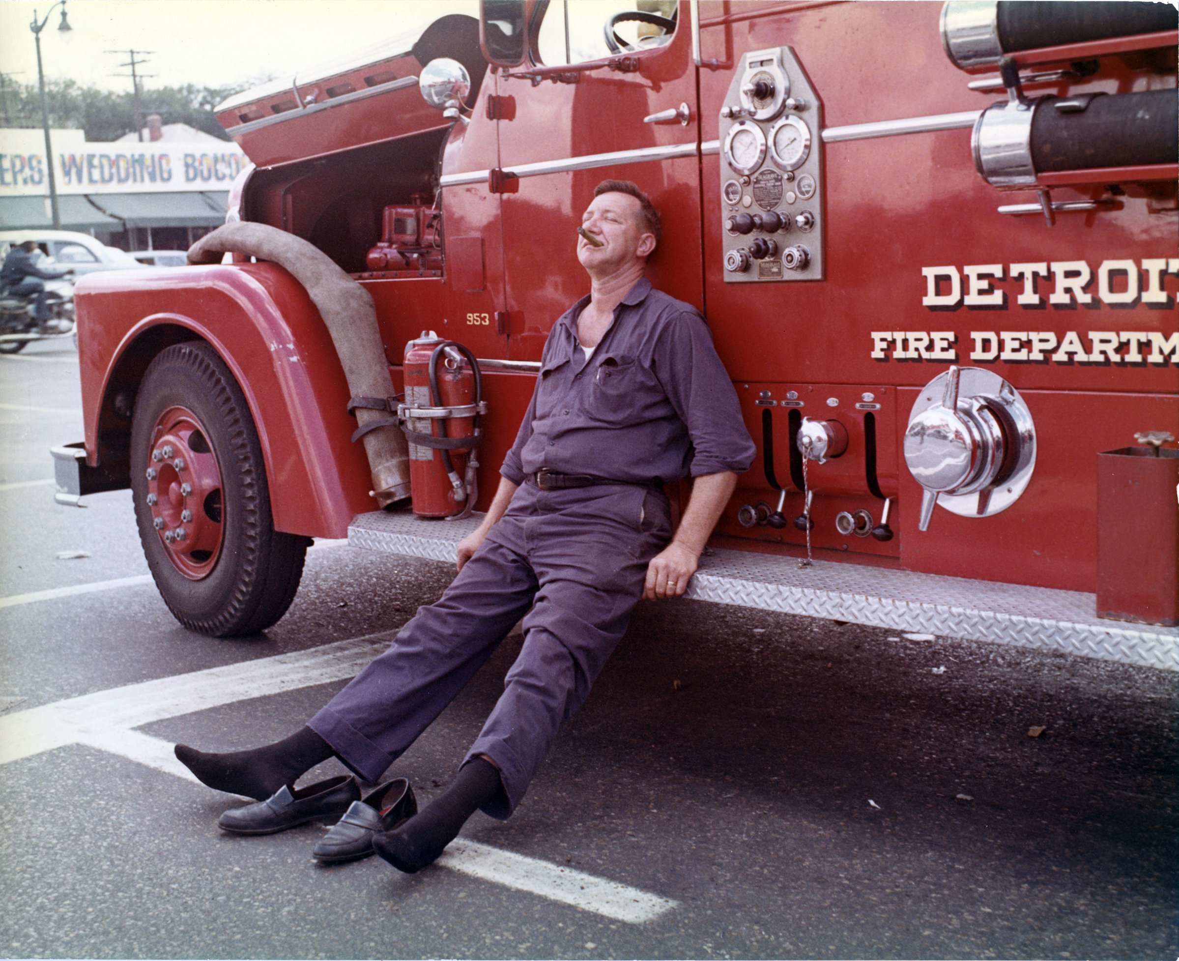 A Detroit firefighter collapses against the side of a department vehicle after battling one of the 1,609 structures that were damaged in the city during the July ’67 protests.