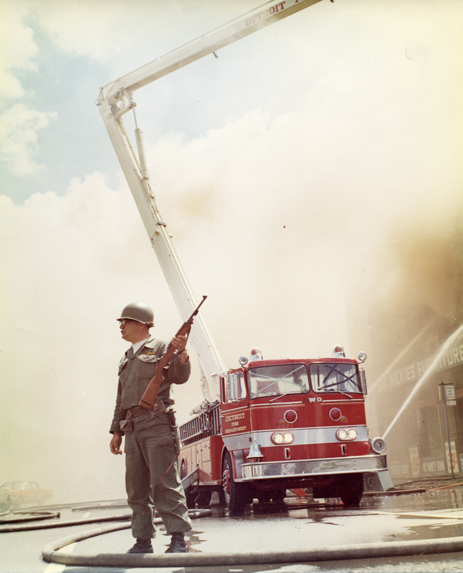 A U.S. army soldier watches the streets while the Detroit Fire Department extinguishes a blaze at Nickie’s Furniture store on Grand River Avenue near Forest in Detroit.