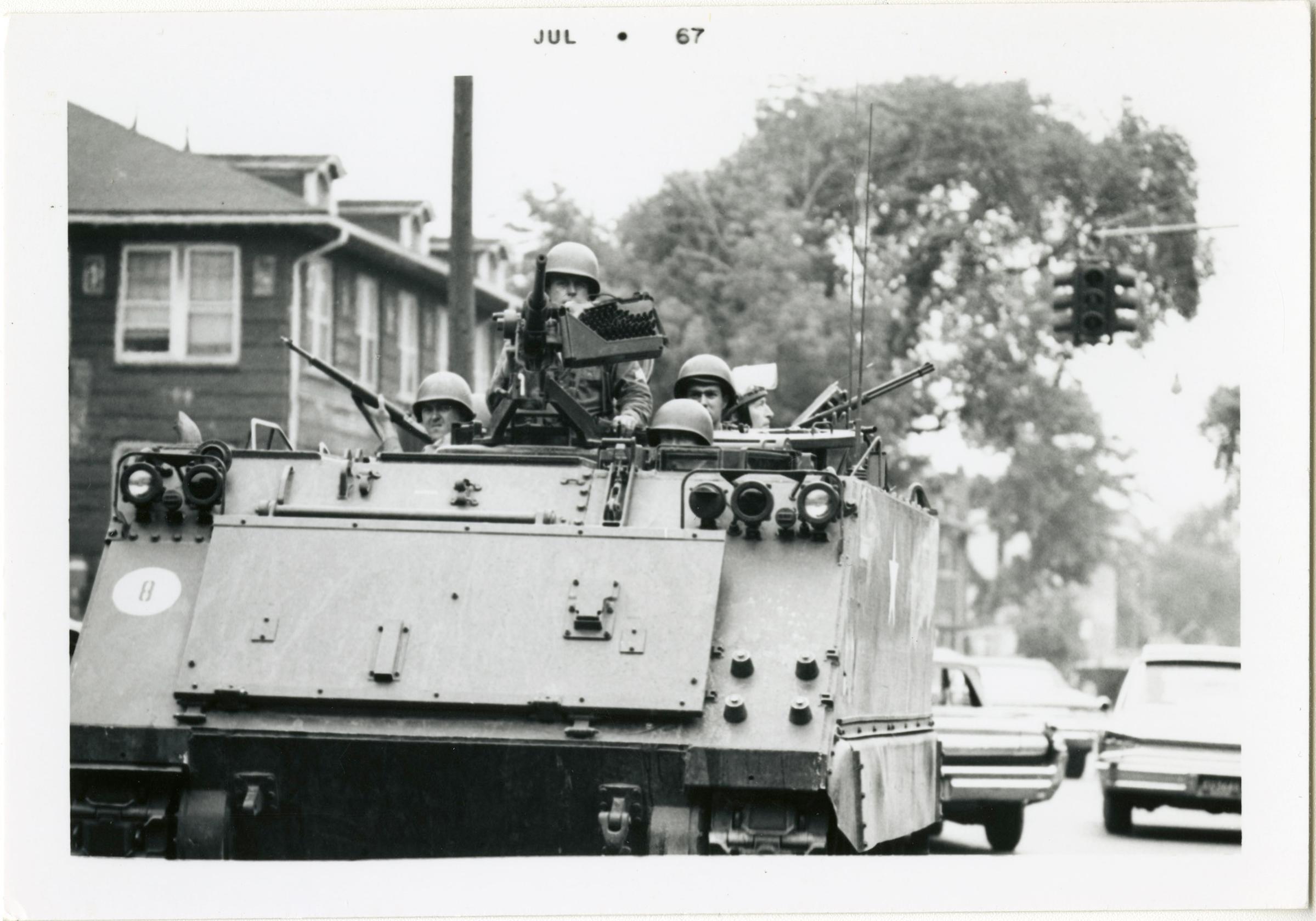 Michigan National Guardsmen patrol the streets of Detroit in an armored personal carrier, also known as a tank.